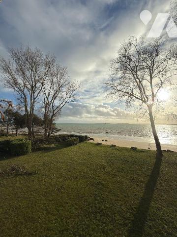 En première ligne face à la mer, au sein d'une maison de maître implantée sur un terrain arboré...