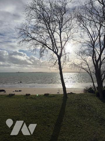 En première ligne face à la mer, au sein d'une maison de maître implantée sur un terrain arboré...