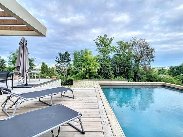 L’art de vivre contemporain aux portes de Paris! 
Située dans un environnement résidentiel privilégié en bord de Seine, cette exceptionnelle villa d’architecte neuve de 357 m² habitables offre un panorama spectaculaire sur la Seine, La Défense et la Tour Eiffel.
Édifiée sur un terrain paysager de 1 744 m², cette propriété séduit par ses volumes généreux, sa luminosité omniprésente, ses prestations haut de gamme et son architecture contemporaine ouverte sur l’extérieur. Les vastes terrasses bois avec claustras et brise-soleil, la piscine de 46 m²chauffée avec espace détente et une cuisine d’été et le séjour cathédrale avec cheminée centrale 360° créent une atmosphère unique entre élégance, confort et art de vivre.

Une distribution pensée pour le confort et la réception. 
•	11 pièces principales 
•	8 chambres dont 3 avec accès terrasse et 1 avec accès PMR
•	Suite parentale avec dressing, salle de bains et terrasse 
•	7 salles d’eau dont 6 privatives 
•	Salle à manger et séjour cathédrale avec vue panoramique 
•	Cuisine américaine avec cellier fermé
•	Appartement indépendant avec 2 chambres et 1 séjour cuisine américaine
•	Garage fermé 3 véhicules + stationnements extérieurs 
À cela s’ajoutent plusieurs espaces annexes non comptabilisés dans la surface habitable : une buanderie, une cave à vins et deux locaux techniques dédiés à la piscine de 46 m² ainsi qu’aux équipements énergétiques de la propriété, pompes à chaleur et centrale double flux.

Rez-de-chaussée surélevé: 
Le niveau principal offre une cuisine américaine avec cellier ouverte sur un spectaculaire séjour cathédrale avec cheminée centrale 360°, baigné de lumière et prolongé par les terrasses et la piscine.
Une salle à manger élégante complète les espaces de réception.
Ce niveau accueille également :
- une chambre avec salle d’eau et WC accessibles PMR (rampe extérieure),
- une suite parentale avec terrasse, dressing, salle de bains avec baignoire et douche à l’italienne double ciel de pluie, ainsi que des WC séparés.

Étage: 
Un élégant escalier sculptural en bois massif, conçu comme une estrade bibliothèque contemporaine, mène à l’étage desservi par une passerelle architecturale.
L’espace nuit comprend :
- 4 chambres avec salle d’eau privative, dont 2 avec terrasse et vue panoramique,
- 2 WC séparés,
- Rangements et gaine à linge reliant directement la buanderie.

Rez-de-jardin : 
Le rez-de-jardin propose des espaces fonctionnels comprenant une entrée indépendante, un vestiaire, une buanderie, une cave à vins, des rangements et un local technique équipé de pompes à chaleur et d’une centrale double flux alimentée par panneaux solaires et photovoltaïques.
Un appartement indépendant complète ce niveau avec:
- séjour et cuisine ouverte
- 2 chambres
- 1 salle d’eau et WC séparés

Environnement & cadre de vie
Cadre résidentiel privilégié en bord de Seine, offrant un équilibre rare entre nature et proximité de Paris.
•	Berges de Seine et chemin de halage à 2 min à pied 
•	Parcours des Impressionnistes à proximité 
•	Île des Impressionnistes de Chatou à 10 min 
•	Jardins de Mademoiselle de La Vallière à 10 min à pied 
Vie de quartier & commodités
À seulement 12 km de Paris, accès rapide aux transports et principaux pôles d’affaires.
•	Gare Houilles / Carrières-sur-Seine (RER A, lignes J & L) à 10 min 
•	Paris Saint-Lazare en 24 min 
•	Accès rapide A86, A14 et La Défense 
•	Commerces et supermarchés à proximité immédiate 

Établissements scolaires
Écoles, collège et lycée accessibles rapidement.
Établissements bilingues et internationaux à proximité : Montessori bilingue, The British School of Paris, Lycée International de Saint-Germain-en-Laye et Ermitage International School.

Prestations & équipements haut de gamme
•	Construction RT 2012 – Prestations énergétiques premium DPE A
•	Plancher chauffant et rafraîchissant sur 3 niveaux 
•	Pompe à chaleur, climatisation et centrale double flux 
•	Panneaux solaires hybrides et photovoltaïques 
•	Menuiseries aluminium, double vitrage et volets motorisés 
•	Cheminée centrale 360° 
•	Piscine chauffée avec espace détente 
•	3 Terrasses bois et pierre avec brise-soleil et claustras 
•	Garage fermé 3 véhicules + stationnements extérieurs 
•	Matériaux nobles et finitions premium

Une propriété rare destinée aux amateurs de lieux uniques recherchant un équilibre parfait entre nature, architecture contemporaine et proximité immédiate de Paris.
Découvrez cette propriété d’exception lors d’une visite privée.