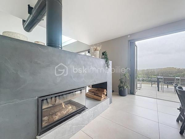 L’art de vivre contemporain aux portes de Paris! 
Située dans un environnement résidentiel privilégié en bord de Seine, cette exceptionnelle villa d’architecte neuve de 357 m² habitables offre un panorama spectaculaire sur la Seine, La Défense et la Tour Eiffel.
Édifiée sur un terrain paysager de 1 744 m², cette propriété séduit par ses volumes généreux, sa luminosité omniprésente, ses prestations haut de gamme et son architecture contemporaine ouverte sur l’extérieur. Les vastes terrasses bois avec claustras et brise-soleil, la piscine de 46 m²chauffée avec espace détente et une cuisine d’été et le séjour cathédrale avec cheminée centrale 360° créent une atmosphère unique entre élégance, confort et art de vivre.

Une distribution pensée pour le confort et la réception. 
•	11 pièces principales 
•	8 chambres dont 3 avec accès terrasse et 1 avec accès PMR
•	Suite parentale avec dressing, salle de bains et terrasse 
•	7 salles d’eau dont 6 privatives 
•	Salle à manger et séjour cathédrale avec vue panoramique 
•	Cuisine américaine avec cellier fermé
•	Appartement indépendant avec 2 chambres et 1 séjour cuisine américaine
•	Garage fermé 3 véhicules + stationnements extérieurs 
À cela s’ajoutent plusieurs espaces annexes non comptabilisés dans la surface habitable : une buanderie, une cave à vins et deux locaux techniques dédiés à la piscine de 46 m² ainsi qu’aux équipements énergétiques de la propriété, pompes à chaleur et centrale double flux.

Rez-de-chaussée surélevé: 
Le niveau principal offre une cuisine américaine avec cellier ouverte sur un spectaculaire séjour cathédrale avec cheminée centrale 360°, baigné de lumière et prolongé par les terrasses et la piscine.
Une salle à manger élégante complète les espaces de réception.
Ce niveau accueille également :
- une chambre avec salle d’eau et WC accessibles PMR (rampe extérieure),
- une suite parentale avec terrasse, dressing, salle de bains avec baignoire et douche à l’italienne double ciel de pluie, ainsi que des WC séparés.

Étage: 
Un élégant escalier sculptural en bois massif, conçu comme une estrade bibliothèque contemporaine, mène à l’étage desservi par une passerelle architecturale.
L’espace nuit comprend :
- 4 chambres avec salle d’eau privative, dont 2 avec terrasse et vue panoramique,
- 2 WC séparés,
- Rangements et gaine à linge reliant directement la buanderie.

Rez-de-jardin : 
Le rez-de-jardin propose des espaces fonctionnels comprenant une entrée indépendante, un vestiaire, une buanderie, une cave à vins, des rangements et un local technique équipé de pompes à chaleur et d’une centrale double flux alimentée par panneaux solaires et photovoltaïques.
Un appartement indépendant complète ce niveau avec:
- séjour et cuisine ouverte
- 2 chambres
- 1 salle d’eau et WC séparés

Environnement & cadre de vie
Cadre résidentiel privilégié en bord de Seine, offrant un équilibre rare entre nature et proximité de Paris.
•	Berges de Seine et chemin de halage à 2 min à pied 
•	Parcours des Impressionnistes à proximité 
•	Île des Impressionnistes de Chatou à 10 min 
•	Jardins de Mademoiselle de La Vallière à 10 min à pied 
Vie de quartier & commodités
À seulement 12 km de Paris, accès rapide aux transports et principaux pôles d’affaires.
•	Gare Houilles / Carrières-sur-Seine (RER A, lignes J & L) à 10 min 
•	Paris Saint-Lazare en 24 min 
•	Accès rapide A86, A14 et La Défense 
•	Commerces et supermarchés à proximité immédiate 

Établissements scolaires
Écoles, collège et lycée accessibles rapidement.
Établissements bilingues et internationaux à proximité : Montessori bilingue, The British School of Paris, Lycée International de Saint-Germain-en-Laye et Ermitage International School.

Prestations & équipements haut de gamme
•	Construction RT 2012 – Prestations énergétiques premium DPE A
•	Plancher chauffant et rafraîchissant sur 3 niveaux 
•	Pompe à chaleur, climatisation et centrale double flux 
•	Panneaux solaires hybrides et photovoltaïques 
•	Menuiseries aluminium, double vitrage et volets motorisés 
•	Cheminée centrale 360° 
•	Piscine chauffée avec espace détente 
•	3 Terrasses bois et pierre avec brise-soleil et claustras 
•	Garage fermé 3 véhicules + stationnements extérieurs 
•	Matériaux nobles et finitions premium

Une propriété rare destinée aux amateurs de lieux uniques recherchant un équilibre parfait entre nature, architecture contemporaine et proximité immédiate de Paris.
Découvrez cette propriété d’exception lors d’une visite privée.