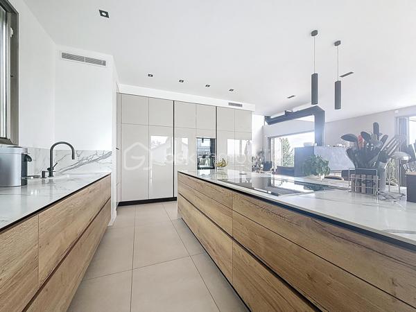 L’art de vivre contemporain aux portes de Paris! 
Située dans un environnement résidentiel privilégié en bord de Seine, cette exceptionnelle villa d’architecte neuve de 357 m² habitables offre un panorama spectaculaire sur la Seine, La Défense et la Tour Eiffel.
Édifiée sur un terrain paysager de 1 744 m², cette propriété séduit par ses volumes généreux, sa luminosité omniprésente, ses prestations haut de gamme et son architecture contemporaine ouverte sur l’extérieur. Les vastes terrasses bois avec claustras et brise-soleil, la piscine de 46 m²chauffée avec espace détente et une cuisine d’été et le séjour cathédrale avec cheminée centrale 360° créent une atmosphère unique entre élégance, confort et art de vivre.

Une distribution pensée pour le confort et la réception. 
•	11 pièces principales 
•	8 chambres dont 3 avec accès terrasse et 1 avec accès PMR
•	Suite parentale avec dressing, salle de bains et terrasse 
•	7 salles d’eau dont 6 privatives 
•	Salle à manger et séjour cathédrale avec vue panoramique 
•	Cuisine américaine avec cellier fermé
•	Appartement indépendant avec 2 chambres et 1 séjour cuisine américaine
•	Garage fermé 3 véhicules + stationnements extérieurs 
À cela s’ajoutent plusieurs espaces annexes non comptabilisés dans la surface habitable : une buanderie, une cave à vins et deux locaux techniques dédiés à la piscine de 46 m² ainsi qu’aux équipements énergétiques de la propriété, pompes à chaleur et centrale double flux.

Rez-de-chaussée surélevé: 
Le niveau principal offre une cuisine américaine avec cellier ouverte sur un spectaculaire séjour cathédrale avec cheminée centrale 360°, baigné de lumière et prolongé par les terrasses et la piscine.
Une salle à manger élégante complète les espaces de réception.
Ce niveau accueille également :
- une chambre avec salle d’eau et WC accessibles PMR (rampe extérieure),
- une suite parentale avec terrasse, dressing, salle de bains avec baignoire et douche à l’italienne double ciel de pluie, ainsi que des WC séparés.

Étage: 
Un élégant escalier sculptural en bois massif, conçu comme une estrade bibliothèque contemporaine, mène à l’étage desservi par une passerelle architecturale.
L’espace nuit comprend :
- 4 chambres avec salle d’eau privative, dont 2 avec terrasse et vue panoramique,
- 2 WC séparés,
- Rangements et gaine à linge reliant directement la buanderie.

Rez-de-jardin : 
Le rez-de-jardin propose des espaces fonctionnels comprenant une entrée indépendante, un vestiaire, une buanderie, une cave à vins, des rangements et un local technique équipé de pompes à chaleur et d’une centrale double flux alimentée par panneaux solaires et photovoltaïques.
Un appartement indépendant complète ce niveau avec:
- séjour et cuisine ouverte
- 2 chambres
- 1 salle d’eau et WC séparés

Environnement & cadre de vie
Cadre résidentiel privilégié en bord de Seine, offrant un équilibre rare entre nature et proximité de Paris.
•	Berges de Seine et chemin de halage à 2 min à pied 
•	Parcours des Impressionnistes à proximité 
•	Île des Impressionnistes de Chatou à 10 min 
•	Jardins de Mademoiselle de La Vallière à 10 min à pied 
Vie de quartier & commodités
À seulement 12 km de Paris, accès rapide aux transports et principaux pôles d’affaires.
•	Gare Houilles / Carrières-sur-Seine (RER A, lignes J & L) à 10 min 
•	Paris Saint-Lazare en 24 min 
•	Accès rapide A86, A14 et La Défense 
•	Commerces et supermarchés à proximité immédiate 

Établissements scolaires
Écoles, collège et lycée accessibles rapidement.
Établissements bilingues et internationaux à proximité : Montessori bilingue, The British School of Paris, Lycée International de Saint-Germain-en-Laye et Ermitage International School.

Prestations & équipements haut de gamme
•	Construction RT 2012 – Prestations énergétiques premium DPE A
•	Plancher chauffant et rafraîchissant sur 3 niveaux 
•	Pompe à chaleur, climatisation et centrale double flux 
•	Panneaux solaires hybrides et photovoltaïques 
•	Menuiseries aluminium, double vitrage et volets motorisés 
•	Cheminée centrale 360° 
•	Piscine chauffée avec espace détente 
•	3 Terrasses bois et pierre avec brise-soleil et claustras 
•	Garage fermé 3 véhicules + stationnements extérieurs 
•	Matériaux nobles et finitions premium

Une propriété rare destinée aux amateurs de lieux uniques recherchant un équilibre parfait entre nature, architecture contemporaine et proximité immédiate de Paris.
Découvrez cette propriété d’exception lors d’une visite privée.