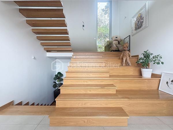 L’art de vivre contemporain aux portes de Paris! 
Située dans un environnement résidentiel privilégié en bord de Seine, cette exceptionnelle villa d’architecte neuve de 357 m² habitables offre un panorama spectaculaire sur la Seine, La Défense et la Tour Eiffel.
Édifiée sur un terrain paysager de 1 744 m², cette propriété séduit par ses volumes généreux, sa luminosité omniprésente, ses prestations haut de gamme et son architecture contemporaine ouverte sur l’extérieur. Les vastes terrasses bois avec claustras et brise-soleil, la piscine de 46 m²chauffée avec espace détente et une cuisine d’été et le séjour cathédrale avec cheminée centrale 360° créent une atmosphère unique entre élégance, confort et art de vivre.

Une distribution pensée pour le confort et la réception. 
•	11 pièces principales 
•	8 chambres dont 3 avec accès terrasse et 1 avec accès PMR
•	Suite parentale avec dressing, salle de bains et terrasse 
•	7 salles d’eau dont 6 privatives 
•	Salle à manger et séjour cathédrale avec vue panoramique 
•	Cuisine américaine avec cellier fermé
•	Appartement indépendant avec 2 chambres et 1 séjour cuisine américaine
•	Garage fermé 3 véhicules + stationnements extérieurs 
À cela s’ajoutent plusieurs espaces annexes non comptabilisés dans la surface habitable : une buanderie, une cave à vins et deux locaux techniques dédiés à la piscine de 46 m² ainsi qu’aux équipements énergétiques de la propriété, pompes à chaleur et centrale double flux.

Rez-de-chaussée surélevé: 
Le niveau principal offre une cuisine américaine avec cellier ouverte sur un spectaculaire séjour cathédrale avec cheminée centrale 360°, baigné de lumière et prolongé par les terrasses et la piscine.
Une salle à manger élégante complète les espaces de réception.
Ce niveau accueille également :
- une chambre avec salle d’eau et WC accessibles PMR (rampe extérieure),
- une suite parentale avec terrasse, dressing, salle de bains avec baignoire et douche à l’italienne double ciel de pluie, ainsi que des WC séparés.

Étage: 
Un élégant escalier sculptural en bois massif, conçu comme une estrade bibliothèque contemporaine, mène à l’étage desservi par une passerelle architecturale.
L’espace nuit comprend :
- 4 chambres avec salle d’eau privative, dont 2 avec terrasse et vue panoramique,
- 2 WC séparés,
- Rangements et gaine à linge reliant directement la buanderie.

Rez-de-jardin : 
Le rez-de-jardin propose des espaces fonctionnels comprenant une entrée indépendante, un vestiaire, une buanderie, une cave à vins, des rangements et un local technique équipé de pompes à chaleur et d’une centrale double flux alimentée par panneaux solaires et photovoltaïques.
Un appartement indépendant complète ce niveau avec:
- séjour et cuisine ouverte
- 2 chambres
- 1 salle d’eau et WC séparés

Environnement & cadre de vie
Cadre résidentiel privilégié en bord de Seine, offrant un équilibre rare entre nature et proximité de Paris.
•	Berges de Seine et chemin de halage à 2 min à pied 
•	Parcours des Impressionnistes à proximité 
•	Île des Impressionnistes de Chatou à 10 min 
•	Jardins de Mademoiselle de La Vallière à 10 min à pied 
Vie de quartier & commodités
À seulement 12 km de Paris, accès rapide aux transports et principaux pôles d’affaires.
•	Gare Houilles / Carrières-sur-Seine (RER A, lignes J & L) à 10 min 
•	Paris Saint-Lazare en 24 min 
•	Accès rapide A86, A14 et La Défense 
•	Commerces et supermarchés à proximité immédiate 

Établissements scolaires
Écoles, collège et lycée accessibles rapidement.
Établissements bilingues et internationaux à proximité : Montessori bilingue, The British School of Paris, Lycée International de Saint-Germain-en-Laye et Ermitage International School.

Prestations & équipements haut de gamme
•	Construction RT 2012 – Prestations énergétiques premium DPE A
•	Plancher chauffant et rafraîchissant sur 3 niveaux 
•	Pompe à chaleur, climatisation et centrale double flux 
•	Panneaux solaires hybrides et photovoltaïques 
•	Menuiseries aluminium, double vitrage et volets motorisés 
•	Cheminée centrale 360° 
•	Piscine chauffée avec espace détente 
•	3 Terrasses bois et pierre avec brise-soleil et claustras 
•	Garage fermé 3 véhicules + stationnements extérieurs 
•	Matériaux nobles et finitions premium

Une propriété rare destinée aux amateurs de lieux uniques recherchant un équilibre parfait entre nature, architecture contemporaine et proximité immédiate de Paris.
Découvrez cette propriété d’exception lors d’une visite privée.