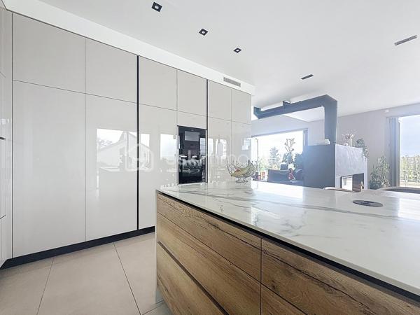 L’art de vivre contemporain aux portes de Paris! 
Située dans un environnement résidentiel privilégié en bord de Seine, cette exceptionnelle villa d’architecte neuve de 357 m² habitables offre un panorama spectaculaire sur la Seine, La Défense et la Tour Eiffel.
Édifiée sur un terrain paysager de 1 744 m², cette propriété séduit par ses volumes généreux, sa luminosité omniprésente, ses prestations haut de gamme et son architecture contemporaine ouverte sur l’extérieur. Les vastes terrasses bois avec claustras et brise-soleil, la piscine de 46 m²chauffée avec espace détente et une cuisine d’été et le séjour cathédrale avec cheminée centrale 360° créent une atmosphère unique entre élégance, confort et art de vivre.

Une distribution pensée pour le confort et la réception. 
•	11 pièces principales 
•	8 chambres dont 3 avec accès terrasse et 1 avec accès PMR
•	Suite parentale avec dressing, salle de bains et terrasse 
•	7 salles d’eau dont 6 privatives 
•	Salle à manger et séjour cathédrale avec vue panoramique 
•	Cuisine américaine avec cellier fermé
•	Appartement indépendant avec 2 chambres et 1 séjour cuisine américaine
•	Garage fermé 3 véhicules + stationnements extérieurs 
À cela s’ajoutent plusieurs espaces annexes non comptabilisés dans la surface habitable : une buanderie, une cave à vins et deux locaux techniques dédiés à la piscine de 46 m² ainsi qu’aux équipements énergétiques de la propriété, pompes à chaleur et centrale double flux.

Rez-de-chaussée surélevé: 
Le niveau principal offre une cuisine américaine avec cellier ouverte sur un spectaculaire séjour cathédrale avec cheminée centrale 360°, baigné de lumière et prolongé par les terrasses et la piscine.
Une salle à manger élégante complète les espaces de réception.
Ce niveau accueille également :
- une chambre avec salle d’eau et WC accessibles PMR (rampe extérieure),
- une suite parentale avec terrasse, dressing, salle de bains avec baignoire et douche à l’italienne double ciel de pluie, ainsi que des WC séparés.

Étage: 
Un élégant escalier sculptural en bois massif, conçu comme une estrade bibliothèque contemporaine, mène à l’étage desservi par une passerelle architecturale.
L’espace nuit comprend :
- 4 chambres avec salle d’eau privative, dont 2 avec terrasse et vue panoramique,
- 2 WC séparés,
- Rangements et gaine à linge reliant directement la buanderie.

Rez-de-jardin : 
Le rez-de-jardin propose des espaces fonctionnels comprenant une entrée indépendante, un vestiaire, une buanderie, une cave à vins, des rangements et un local technique équipé de pompes à chaleur et d’une centrale double flux alimentée par panneaux solaires et photovoltaïques.
Un appartement indépendant complète ce niveau avec:
- séjour et cuisine ouverte
- 2 chambres
- 1 salle d’eau et WC séparés

Environnement & cadre de vie
Cadre résidentiel privilégié en bord de Seine, offrant un équilibre rare entre nature et proximité de Paris.
•	Berges de Seine et chemin de halage à 2 min à pied 
•	Parcours des Impressionnistes à proximité 
•	Île des Impressionnistes de Chatou à 10 min 
•	Jardins de Mademoiselle de La Vallière à 10 min à pied 
Vie de quartier & commodités
À seulement 12 km de Paris, accès rapide aux transports et principaux pôles d’affaires.
•	Gare Houilles / Carrières-sur-Seine (RER A, lignes J & L) à 10 min 
•	Paris Saint-Lazare en 24 min 
•	Accès rapide A86, A14 et La Défense 
•	Commerces et supermarchés à proximité immédiate 

Établissements scolaires
Écoles, collège et lycée accessibles rapidement.
Établissements bilingues et internationaux à proximité : Montessori bilingue, The British School of Paris, Lycée International de Saint-Germain-en-Laye et Ermitage International School.

Prestations & équipements haut de gamme
•	Construction RT 2012 – Prestations énergétiques premium DPE A
•	Plancher chauffant et rafraîchissant sur 3 niveaux 
•	Pompe à chaleur, climatisation et centrale double flux 
•	Panneaux solaires hybrides et photovoltaïques 
•	Menuiseries aluminium, double vitrage et volets motorisés 
•	Cheminée centrale 360° 
•	Piscine chauffée avec espace détente 
•	3 Terrasses bois et pierre avec brise-soleil et claustras 
•	Garage fermé 3 véhicules + stationnements extérieurs 
•	Matériaux nobles et finitions premium

Une propriété rare destinée aux amateurs de lieux uniques recherchant un équilibre parfait entre nature, architecture contemporaine et proximité immédiate de Paris.
Découvrez cette propriété d’exception lors d’une visite privée.