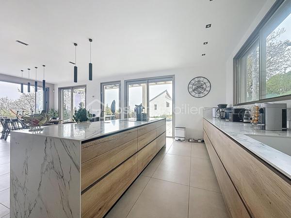 L’art de vivre contemporain aux portes de Paris! 
Située dans un environnement résidentiel privilégié en bord de Seine, cette exceptionnelle villa d’architecte neuve de 357 m² habitables offre un panorama spectaculaire sur la Seine, La Défense et la Tour Eiffel.
Édifiée sur un terrain paysager de 1 744 m², cette propriété séduit par ses volumes généreux, sa luminosité omniprésente, ses prestations haut de gamme et son architecture contemporaine ouverte sur l’extérieur. Les vastes terrasses bois avec claustras et brise-soleil, la piscine de 46 m²chauffée avec espace détente et une cuisine d’été et le séjour cathédrale avec cheminée centrale 360° créent une atmosphère unique entre élégance, confort et art de vivre.

Une distribution pensée pour le confort et la réception. 
•	11 pièces principales 
•	8 chambres dont 3 avec accès terrasse et 1 avec accès PMR
•	Suite parentale avec dressing, salle de bains et terrasse 
•	7 salles d’eau dont 6 privatives 
•	Salle à manger et séjour cathédrale avec vue panoramique 
•	Cuisine américaine avec cellier fermé
•	Appartement indépendant avec 2 chambres et 1 séjour cuisine américaine
•	Garage fermé 3 véhicules + stationnements extérieurs 
À cela s’ajoutent plusieurs espaces annexes non comptabilisés dans la surface habitable : une buanderie, une cave à vins et deux locaux techniques dédiés à la piscine de 46 m² ainsi qu’aux équipements énergétiques de la propriété, pompes à chaleur et centrale double flux.

Rez-de-chaussée surélevé: 
Le niveau principal offre une cuisine américaine avec cellier ouverte sur un spectaculaire séjour cathédrale avec cheminée centrale 360°, baigné de lumière et prolongé par les terrasses et la piscine.
Une salle à manger élégante complète les espaces de réception.
Ce niveau accueille également :
- une chambre avec salle d’eau et WC accessibles PMR (rampe extérieure),
- une suite parentale avec terrasse, dressing, salle de bains avec baignoire et douche à l’italienne double ciel de pluie, ainsi que des WC séparés.

Étage: 
Un élégant escalier sculptural en bois massif, conçu comme une estrade bibliothèque contemporaine, mène à l’étage desservi par une passerelle architecturale.
L’espace nuit comprend :
- 4 chambres avec salle d’eau privative, dont 2 avec terrasse et vue panoramique,
- 2 WC séparés,
- Rangements et gaine à linge reliant directement la buanderie.

Rez-de-jardin : 
Le rez-de-jardin propose des espaces fonctionnels comprenant une entrée indépendante, un vestiaire, une buanderie, une cave à vins, des rangements et un local technique équipé de pompes à chaleur et d’une centrale double flux alimentée par panneaux solaires et photovoltaïques.
Un appartement indépendant complète ce niveau avec:
- séjour et cuisine ouverte
- 2 chambres
- 1 salle d’eau et WC séparés

Environnement & cadre de vie
Cadre résidentiel privilégié en bord de Seine, offrant un équilibre rare entre nature et proximité de Paris.
•	Berges de Seine et chemin de halage à 2 min à pied 
•	Parcours des Impressionnistes à proximité 
•	Île des Impressionnistes de Chatou à 10 min 
•	Jardins de Mademoiselle de La Vallière à 10 min à pied 
Vie de quartier & commodités
À seulement 12 km de Paris, accès rapide aux transports et principaux pôles d’affaires.
•	Gare Houilles / Carrières-sur-Seine (RER A, lignes J & L) à 10 min 
•	Paris Saint-Lazare en 24 min 
•	Accès rapide A86, A14 et La Défense 
•	Commerces et supermarchés à proximité immédiate 

Établissements scolaires
Écoles, collège et lycée accessibles rapidement.
Établissements bilingues et internationaux à proximité : Montessori bilingue, The British School of Paris, Lycée International de Saint-Germain-en-Laye et Ermitage International School.

Prestations & équipements haut de gamme
•	Construction RT 2012 – Prestations énergétiques premium DPE A
•	Plancher chauffant et rafraîchissant sur 3 niveaux 
•	Pompe à chaleur, climatisation et centrale double flux 
•	Panneaux solaires hybrides et photovoltaïques 
•	Menuiseries aluminium, double vitrage et volets motorisés 
•	Cheminée centrale 360° 
•	Piscine chauffée avec espace détente 
•	3 Terrasses bois et pierre avec brise-soleil et claustras 
•	Garage fermé 3 véhicules + stationnements extérieurs 
•	Matériaux nobles et finitions premium

Une propriété rare destinée aux amateurs de lieux uniques recherchant un équilibre parfait entre nature, architecture contemporaine et proximité immédiate de Paris.
Découvrez cette propriété d’exception lors d’une visite privée.