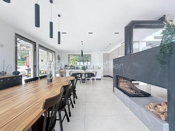 L’art de vivre contemporain aux portes de Paris! 
Située dans un environnement résidentiel privilégié en bord de Seine, cette exceptionnelle villa d’architecte neuve de 357 m² habitables offre un panorama spectaculaire sur la Seine, La Défense et la Tour Eiffel.
Édifiée sur un terrain paysager de 1 744 m², cette propriété séduit par ses volumes généreux, sa luminosité omniprésente, ses prestations haut de gamme et son architecture contemporaine ouverte sur l’extérieur. Les vastes terrasses bois avec claustras et brise-soleil, la piscine de 46 m²chauffée avec espace détente et une cuisine d’été et le séjour cathédrale avec cheminée centrale 360° créent une atmosphère unique entre élégance, confort et art de vivre.

Une distribution pensée pour le confort et la réception. 
•	11 pièces principales 
•	8 chambres dont 3 avec accès terrasse et 1 avec accès PMR
•	Suite parentale avec dressing, salle de bains et terrasse 
•	7 salles d’eau dont 6 privatives 
•	Salle à manger et séjour cathédrale avec vue panoramique 
•	Cuisine américaine avec cellier fermé
•	Appartement indépendant avec 2 chambres et 1 séjour cuisine américaine
•	Garage fermé 3 véhicules + stationnements extérieurs 
À cela s’ajoutent plusieurs espaces annexes non comptabilisés dans la surface habitable : une buanderie, une cave à vins et deux locaux techniques dédiés à la piscine de 46 m² ainsi qu’aux équipements énergétiques de la propriété, pompes à chaleur et centrale double flux.

Rez-de-chaussée surélevé: 
Le niveau principal offre une cuisine américaine avec cellier ouverte sur un spectaculaire séjour cathédrale avec cheminée centrale 360°, baigné de lumière et prolongé par les terrasses et la piscine.
Une salle à manger élégante complète les espaces de réception.
Ce niveau accueille également :
- une chambre avec salle d’eau et WC accessibles PMR (rampe extérieure),
- une suite parentale avec terrasse, dressing, salle de bains avec baignoire et douche à l’italienne double ciel de pluie, ainsi que des WC séparés.

Étage: 
Un élégant escalier sculptural en bois massif, conçu comme une estrade bibliothèque contemporaine, mène à l’étage desservi par une passerelle architecturale.
L’espace nuit comprend :
- 4 chambres avec salle d’eau privative, dont 2 avec terrasse et vue panoramique,
- 2 WC séparés,
- Rangements et gaine à linge reliant directement la buanderie.

Rez-de-jardin : 
Le rez-de-jardin propose des espaces fonctionnels comprenant une entrée indépendante, un vestiaire, une buanderie, une cave à vins, des rangements et un local technique équipé de pompes à chaleur et d’une centrale double flux alimentée par panneaux solaires et photovoltaïques.
Un appartement indépendant complète ce niveau avec:
- séjour et cuisine ouverte
- 2 chambres
- 1 salle d’eau et WC séparés

Environnement & cadre de vie
Cadre résidentiel privilégié en bord de Seine, offrant un équilibre rare entre nature et proximité de Paris.
•	Berges de Seine et chemin de halage à 2 min à pied 
•	Parcours des Impressionnistes à proximité 
•	Île des Impressionnistes de Chatou à 10 min 
•	Jardins de Mademoiselle de La Vallière à 10 min à pied 
Vie de quartier & commodités
À seulement 12 km de Paris, accès rapide aux transports et principaux pôles d’affaires.
•	Gare Houilles / Carrières-sur-Seine (RER A, lignes J & L) à 10 min 
•	Paris Saint-Lazare en 24 min 
•	Accès rapide A86, A14 et La Défense 
•	Commerces et supermarchés à proximité immédiate 

Établissements scolaires
Écoles, collège et lycée accessibles rapidement.
Établissements bilingues et internationaux à proximité : Montessori bilingue, The British School of Paris, Lycée International de Saint-Germain-en-Laye et Ermitage International School.

Prestations & équipements haut de gamme
•	Construction RT 2012 – Prestations énergétiques premium DPE A
•	Plancher chauffant et rafraîchissant sur 3 niveaux 
•	Pompe à chaleur, climatisation et centrale double flux 
•	Panneaux solaires hybrides et photovoltaïques 
•	Menuiseries aluminium, double vitrage et volets motorisés 
•	Cheminée centrale 360° 
•	Piscine chauffée avec espace détente 
•	3 Terrasses bois et pierre avec brise-soleil et claustras 
•	Garage fermé 3 véhicules + stationnements extérieurs 
•	Matériaux nobles et finitions premium

Une propriété rare destinée aux amateurs de lieux uniques recherchant un équilibre parfait entre nature, architecture contemporaine et proximité immédiate de Paris.
Découvrez cette propriété d’exception lors d’une visite privée.