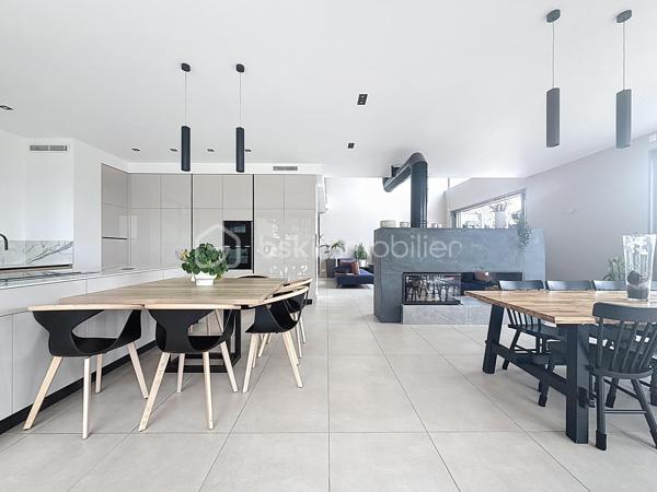 L’art de vivre contemporain aux portes de Paris! 
Située dans un environnement résidentiel privilégié en bord de Seine, cette exceptionnelle villa d’architecte neuve de 357 m² habitables offre un panorama spectaculaire sur la Seine, La Défense et la Tour Eiffel.
Édifiée sur un terrain paysager de 1 744 m², cette propriété séduit par ses volumes généreux, sa luminosité omniprésente, ses prestations haut de gamme et son architecture contemporaine ouverte sur l’extérieur. Les vastes terrasses bois avec claustras et brise-soleil, la piscine de 46 m²chauffée avec espace détente et une cuisine d’été et le séjour cathédrale avec cheminée centrale 360° créent une atmosphère unique entre élégance, confort et art de vivre.

Une distribution pensée pour le confort et la réception. 
•	11 pièces principales 
•	8 chambres dont 3 avec accès terrasse et 1 avec accès PMR
•	Suite parentale avec dressing, salle de bains et terrasse 
•	7 salles d’eau dont 6 privatives 
•	Salle à manger et séjour cathédrale avec vue panoramique 
•	Cuisine américaine avec cellier fermé
•	Appartement indépendant avec 2 chambres et 1 séjour cuisine américaine
•	Garage fermé 3 véhicules + stationnements extérieurs 
À cela s’ajoutent plusieurs espaces annexes non comptabilisés dans la surface habitable : une buanderie, une cave à vins et deux locaux techniques dédiés à la piscine de 46 m² ainsi qu’aux équipements énergétiques de la propriété, pompes à chaleur et centrale double flux.

Rez-de-chaussée surélevé: 
Le niveau principal offre une cuisine américaine avec cellier ouverte sur un spectaculaire séjour cathédrale avec cheminée centrale 360°, baigné de lumière et prolongé par les terrasses et la piscine.
Une salle à manger élégante complète les espaces de réception.
Ce niveau accueille également :
- une chambre avec salle d’eau et WC accessibles PMR (rampe extérieure),
- une suite parentale avec terrasse, dressing, salle de bains avec baignoire et douche à l’italienne double ciel de pluie, ainsi que des WC séparés.

Étage: 
Un élégant escalier sculptural en bois massif, conçu comme une estrade bibliothèque contemporaine, mène à l’étage desservi par une passerelle architecturale.
L’espace nuit comprend :
- 4 chambres avec salle d’eau privative, dont 2 avec terrasse et vue panoramique,
- 2 WC séparés,
- Rangements et gaine à linge reliant directement la buanderie.

Rez-de-jardin : 
Le rez-de-jardin propose des espaces fonctionnels comprenant une entrée indépendante, un vestiaire, une buanderie, une cave à vins, des rangements et un local technique équipé de pompes à chaleur et d’une centrale double flux alimentée par panneaux solaires et photovoltaïques.
Un appartement indépendant complète ce niveau avec:
- séjour et cuisine ouverte
- 2 chambres
- 1 salle d’eau et WC séparés

Environnement & cadre de vie
Cadre résidentiel privilégié en bord de Seine, offrant un équilibre rare entre nature et proximité de Paris.
•	Berges de Seine et chemin de halage à 2 min à pied 
•	Parcours des Impressionnistes à proximité 
•	Île des Impressionnistes de Chatou à 10 min 
•	Jardins de Mademoiselle de La Vallière à 10 min à pied 
Vie de quartier & commodités
À seulement 12 km de Paris, accès rapide aux transports et principaux pôles d’affaires.
•	Gare Houilles / Carrières-sur-Seine (RER A, lignes J & L) à 10 min 
•	Paris Saint-Lazare en 24 min 
•	Accès rapide A86, A14 et La Défense 
•	Commerces et supermarchés à proximité immédiate 

Établissements scolaires
Écoles, collège et lycée accessibles rapidement.
Établissements bilingues et internationaux à proximité : Montessori bilingue, The British School of Paris, Lycée International de Saint-Germain-en-Laye et Ermitage International School.

Prestations & équipements haut de gamme
•	Construction RT 2012 – Prestations énergétiques premium DPE A
•	Plancher chauffant et rafraîchissant sur 3 niveaux 
•	Pompe à chaleur, climatisation et centrale double flux 
•	Panneaux solaires hybrides et photovoltaïques 
•	Menuiseries aluminium, double vitrage et volets motorisés 
•	Cheminée centrale 360° 
•	Piscine chauffée avec espace détente 
•	3 Terrasses bois et pierre avec brise-soleil et claustras 
•	Garage fermé 3 véhicules + stationnements extérieurs 
•	Matériaux nobles et finitions premium

Une propriété rare destinée aux amateurs de lieux uniques recherchant un équilibre parfait entre nature, architecture contemporaine et proximité immédiate de Paris.
Découvrez cette propriété d’exception lors d’une visite privée.