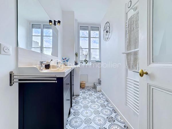 Au cœur d’un bel immeuble ancien en pierre de caractère, découvrez ce superbe appartement familial en duplex situé au quatrième et dernier étage avec ascenseur 

Développant 135 m² Carrez et environ 150 m² de surface utile, ce bien rare séduit immédiatement par ses volumes généreux, sa luminosité, son calme remarquable et son charme authentique préservé.

Traversant, bénéficiant d'une double exposition et d'une magnifique vue dégagée sur les montagnes et la Bastille, l'appartement offre un cadre de vie privilégié tout en profitant d'une très belle cour intérieure arborée et pleine de caractère.

Un premier niveau lumineux et fonctionnel

L'espace de vie principal s'organise autour d'une vaste pièce de réception baignée de lumière grâce à ses grandes ouvertures équipées de double vitrage et de volets roulants électriques.

La cuisine indépendante, entièrement équipée (plaque de cuisson, four et hotte), dispose également d'un espace repas agréable.

L'espace nuit comprend :

Trois belles chambres de caractère
Deux chambres avec placards intégrés
Deux cheminées décoratives apportant charme et authenticité
Une salle d'eau avec douche
Un WC indépendant avec lave-mains
Un vaste cellier pouvant facilement être aménagé en dressing

L'ensemble est sublimé par un véritable parquet massif présent dans toutes les pièces.

Un étage atypique plein de charme

Accessible par un élégant escalier autoportant, le niveau supérieur accueille une grande chambre sous les toits bénéficiant de poutres apparentes, d'un point d'eau et de nombreux espaces de rangement.

Cet ancien galetas aménagé constitue un espace idéal pour une suite parentale, un bureau ou une chambre d'amis.

Des fenêtres de toit (Velux) assurent un excellent apport de lumière naturelle.

Prestations et confort
Chauffage individuel au gaz (chaudière d'environ 10 ans)
Climatisation sur les deux niveaux
Double vitrage
Volets roulants électriques (hors cuisine)
Fibre optique
Ascenseur de plain-pied
Local à vélos
Cave d'environ 16 m²
Galetas complémentaire de 12m²
Très faibles charges de copropriété : environ 1 200 €/an
Taxe foncière : 3 500 €/an
Une copropriété pleine de cachet

Ancienne bâtisse de caractère comprenant notamment une ancienne écurie, la copropriété séduit par sa magnifique cour intérieure végétalisée, son ambiance paisible et quelques places de stationnement.

Les atouts qui font la différence

✓ Dernier étage avec ascenseur
✓ Vue dégagée sur la Bastille et les montagnes
✓ Appartement traversant et très lumineux
✓ Calme absolu
✓ Charme de l'ancien : parquet massif, cheminées, belle hauteur sous plafond
✓ Duplex atypique et familial
✓ Cave et galetas
✓ Climatisation sur les deux niveaux
✓ Faibles charges de copropriété

Un bien rare alliant le cachet de l'ancien, des volumes généreux et une situation privilégiée, idéal pour les amateurs d'appartements de caractère recherchant calme, lumière et vue exceptionnelle.