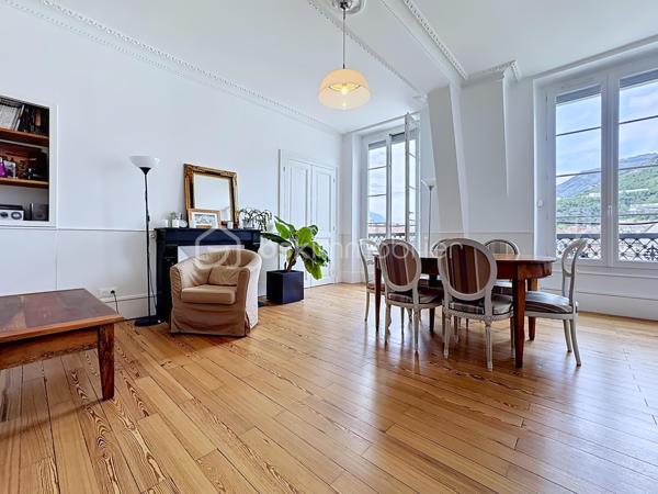 Au cœur d’un bel immeuble ancien en pierre de caractère, découvrez ce superbe appartement familial en duplex situé au quatrième et dernier étage avec ascenseur 

Développant 135 m² Carrez et environ 150 m² de surface utile, ce bien rare séduit immédiatement par ses volumes généreux, sa luminosité, son calme remarquable et son charme authentique préservé.

Traversant, bénéficiant d'une double exposition et d'une magnifique vue dégagée sur les montagnes et la Bastille, l'appartement offre un cadre de vie privilégié tout en profitant d'une très belle cour intérieure arborée et pleine de caractère.

Un premier niveau lumineux et fonctionnel

L'espace de vie principal s'organise autour d'une vaste pièce de réception baignée de lumière grâce à ses grandes ouvertures équipées de double vitrage et de volets roulants électriques.

La cuisine indépendante, entièrement équipée (plaque de cuisson, four et hotte), dispose également d'un espace repas agréable.

L'espace nuit comprend :

Trois belles chambres de caractère
Deux chambres avec placards intégrés
Deux cheminées décoratives apportant charme et authenticité
Une salle d'eau avec douche
Un WC indépendant avec lave-mains
Un vaste cellier pouvant facilement être aménagé en dressing

L'ensemble est sublimé par un véritable parquet massif présent dans toutes les pièces.

Un étage atypique plein de charme

Accessible par un élégant escalier autoportant, le niveau supérieur accueille une grande chambre sous les toits bénéficiant de poutres apparentes, d'un point d'eau et de nombreux espaces de rangement.

Cet ancien galetas aménagé constitue un espace idéal pour une suite parentale, un bureau ou une chambre d'amis.

Des fenêtres de toit (Velux) assurent un excellent apport de lumière naturelle.

Prestations et confort
Chauffage individuel au gaz (chaudière d'environ 10 ans)
Climatisation sur les deux niveaux
Double vitrage
Volets roulants électriques (hors cuisine)
Fibre optique
Ascenseur de plain-pied
Local à vélos
Cave d'environ 16 m²
Galetas complémentaire de 12m²
Très faibles charges de copropriété : environ 1 200 €/an
Taxe foncière : 3 500 €/an
Une copropriété pleine de cachet

Ancienne bâtisse de caractère comprenant notamment une ancienne écurie, la copropriété séduit par sa magnifique cour intérieure végétalisée, son ambiance paisible et quelques places de stationnement.

Les atouts qui font la différence

✓ Dernier étage avec ascenseur
✓ Vue dégagée sur la Bastille et les montagnes
✓ Appartement traversant et très lumineux
✓ Calme absolu
✓ Charme de l'ancien : parquet massif, cheminées, belle hauteur sous plafond
✓ Duplex atypique et familial
✓ Cave et galetas
✓ Climatisation sur les deux niveaux
✓ Faibles charges de copropriété

Un bien rare alliant le cachet de l'ancien, des volumes généreux et une situation privilégiée, idéal pour les amateurs d'appartements de caractère recherchant calme, lumière et vue exceptionnelle.