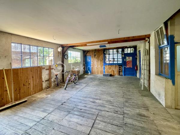 Cette habitation se compose au rez-de-chaussée:

- D’un salon/salle à mangé de 60 m².
- D’une cuisine de 19 m².
- D’une chambre de 21 m².
- D’une cave.

L’étage est composé:

- De quatre chambres de 17 à 20 m².
- D’une salle de bain de 4,5 m².
- D’un toilette.
- Un grenier de 97 m².

La partie garage se compose:

- D’un garage de 67 m².
- De trois ateliers de 30, 35 et 40 m².
- De deux cagibis de 8,5 et 1,5 m².
- D’un bureau de 7 m².
- D’une cave.

L’ancien magasin se compose:

- D’un local vitré sur rue de 28 m².
- D’une cuisine de 12 m².
- D’une chambre de 10 m².

Le tout sur une parcelle de 926 m² sans vis-à-vis, arborée, entièrement close avec terrasse et dépendance.

- Système de chauffage chaudière au fioul et insert à bois.
- Huisseries double vitrage PVC coté rue.
- Assainissement tout-à-l’égout.

Ce bien a un fort potentiel de part sa partie habitation, son grand garage et sa partie ancien magasin pour un potentiel revenu locatif.