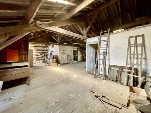 Cette habitation se compose au rez-de-chaussée:

- D’un salon/salle à mangé de 60 m².
- D’une cuisine de 19 m².
- D’une chambre de 21 m².
- D’une cave.

L’étage est composé:

- De quatre chambres de 17 à 20 m².
- D’une salle de bain de 4,5 m².
- D’un toilette.
- Un grenier de 97 m².

La partie garage se compose:

- D’un garage de 67 m².
- De trois ateliers de 30, 35 et 40 m².
- De deux cagibis de 8,5 et 1,5 m².
- D’un bureau de 7 m².
- D’une cave.

L’ancien magasin se compose:

- D’un local vitré sur rue de 28 m².
- D’une cuisine de 12 m².
- D’une chambre de 10 m².

Le tout sur une parcelle de 926 m² sans vis-à-vis, arborée, entièrement close avec terrasse et dépendance.

- Système de chauffage chaudière au fioul et insert à bois.
- Huisseries double vitrage PVC coté rue.
- Assainissement tout-à-l’égout.

Ce bien a un fort potentiel de part sa partie habitation, son grand garage et sa partie ancien magasin pour un potentiel revenu locatif.