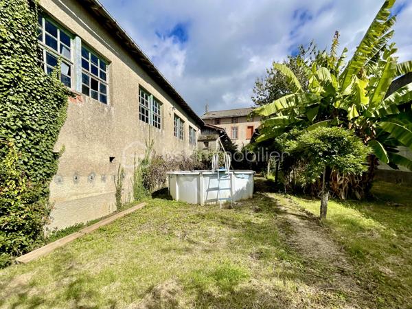 Cette habitation se compose au rez-de-chaussée:

- D’un salon/salle à mangé de 60 m².
- D’une cuisine de 19 m².
- D’une chambre de 21 m².
- D’une cave.

L’étage est composé:

- De quatre chambres de 17 à 20 m².
- D’une salle de bain de 4,5 m².
- D’un toilette.
- Un grenier de 97 m².

La partie garage se compose:

- D’un garage de 67 m².
- De trois ateliers de 30, 35 et 40 m².
- De deux cagibis de 8,5 et 1,5 m².
- D’un bureau de 7 m².
- D’une cave.

L’ancien magasin se compose:

- D’un local vitré sur rue de 28 m².
- D’une cuisine de 12 m².
- D’une chambre de 10 m².

Le tout sur une parcelle de 926 m² sans vis-à-vis, arborée, entièrement close avec terrasse et dépendance.

- Système de chauffage chaudière au fioul et insert à bois.
- Huisseries double vitrage PVC coté rue.
- Assainissement tout-à-l’égout.

Ce bien a un fort potentiel de part sa partie habitation, son grand garage et sa partie ancien magasin pour un potentiel revenu locatif.