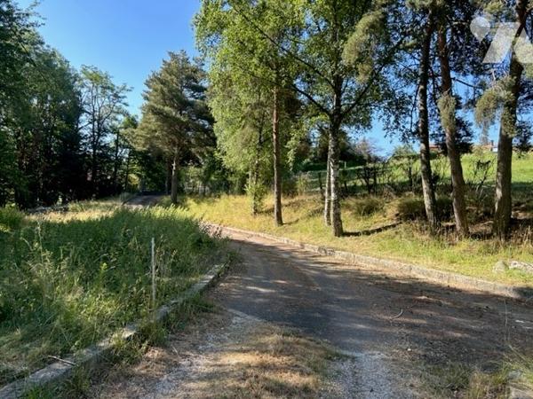 Maison dans la nature avec étang et piscine couverte.