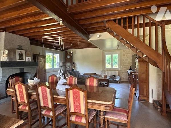 Maison dans la nature avec étang et piscine couverte.