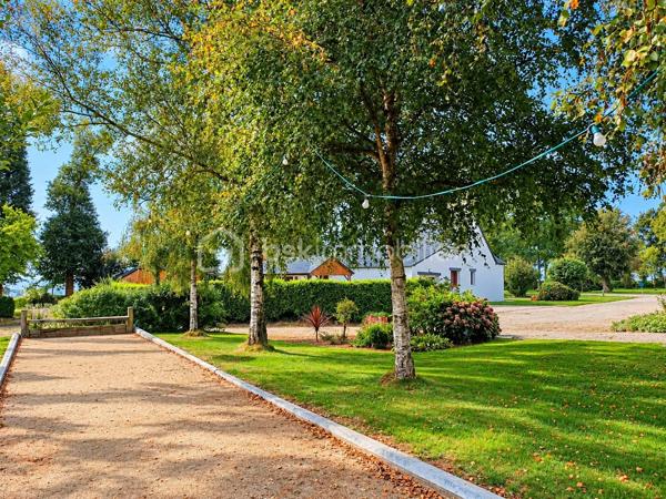 "VISITE VIRTUELLE DISPONIBLE SUR DEMANDE"

À seulement 2 minutes de l’entrée de Josselin, venez découvrir cette maison construite en 1988 et rénovée, offrant de beaux volumes, de nombreuses dépendances et un fort potentiel, le tout implanté sur un vaste terrain d’environ 38 000 m² (3,8 hectares).

Au rez-de-chaussée, vous profiterez d’un spacieux séjour/salon de 49 m² avec cheminée, offrant un bel espace de vie convivial et chaleureux.

La cuisine aménagée et équipée de 15 m², ouverte sur la pièce de vie, bénéficie d’un véritable atout : grâce à sa porte à galandage, elle peut facilement être ouverte ou fermée selon vos envies.

Ce niveau dispose également de deux chambres, d’une salle d’eau et d’un WC indépendant, permettant une vie de plain-pied.

À l’étage, l’espace nuit se poursuit avec trois chambres supplémentaires, une salle d’eau ainsi qu’une buanderie.

En complément, la maison dispose d’un garage, d’une cave et d’une cuisine d’été et d'un puits artésien.

Côté confort, la maison est équipée d’un chauffage par pompe à chaleur.

Un ensemble immobilier aux multiples possibilités

La propriété s’étend sur environ 3,8 hectares et comprend d’importants bâtiments :

un grand poulailler d’environ 2 000 m², pouvant accueillir jusqu’à 40 000 poules et offrant également des possibilités pour d’autres activités ou projets, sous réserve des autorisations nécessaires ;

un hangar d’environ 1 200 m², équipé de panneaux photovoltaïques d’une puissance de 9 kW ;

un terrain de boules, idéal pour profiter des beaux jours.

Cet ensemble offre de nombreuses possibilités d’exploitation, de stockage ou d’aménagement, selon vos projets et la réglementation en vigueur.

Travaux à prévoir : l’assainissement individuel est à refaire.

Une propriété aux caractéristiques rares sur le secteur, réunissant proximité immédiate de Josselin, 5 chambres, 3,8 hectares de terrain et environ 3 200 m² de bâtiments. Un bien à découvrir pour apprécier tout son potentiel.