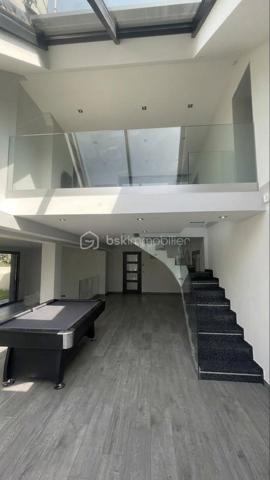Au calme a deux pas du centre ville, au sein d'une voie privée, très belle maison moderne bâtie en 1988 développant 268,5m2 sur 1148 m2 de terrain . 
LES POINTS FORTS DE LA PROPRIÉTÉ
Architecture : Superbes baies vitrées toute hauteur, escaliers design sur mesure (mosaïque d'exception, verre suspendu), finitions soignées et lignes contemporaines.
Luminosité & ouverture : Baies coulissantes XXL ouvrant sur une vaste terrasse en bois plein sud et un jardin arboré sans vis-a-vis.
Espaces de vie de lumière : Un séjour cathédrale magistral avec puits de lumière et mezzanine en verre suspendu.
Cuisine : Cuisine haut de gamme entièrement équipée, arborant un îlot central en granit noir avec table intégrée et mosaïque, lumineuse.
Espace Bien-être & Loisirs : Véranda entièrement vitrée aménagée en salle de sport / espace détente donnant directement sur le jardin.
Rez-de-Chaussée :
Entrée : Entrée accueillante avec WC et rangements.
Cuisine Américaine : Immense cuisine laquée noire avec îlot central, vaste plan de travail, crédence en mosaïque scintillante et équipements encastrés.
Doubles Séjour : Vaste séjour double ultra-lumineux bénéficiant d'une belle hauteur sous plafond et de gardes-corps en verre.
Véranda : Pièce de vie supplémentaire baignée de soleil, idéale pour une salle de fitness, atelier ou salon d'été.
Espaces Techniques : Buanderie/cellier indépendant.
 Étage & Espaces Nuits (Suites
Parentales) :
Mezzanine : Passerelle surplombant le séjour avec puits de lumière et vue dégagée.
Première Suite : Belle chambre donnant sur terrasse/balcon avec vue sur le jardin, dressing, et une salle de bain d'exception équipée d'une baignoire îlot design, douche à l'italienne XXL et double vasque.
Seconde Suite : Grande chambre parentale avec salle d'eau privative ultra-chic (vasques dorées pose sur table, douche à l'italienne, WC suspendu).
Dressing sur-mesure / Bureau : Espace dédié au rangement optimisé sous pente.
Dernier Niveau : 
Accessible par un spectaculaire escalier en
verre design. Vaste suite sous combles avec velux grands formats et sa salle d'eau privative avec WC.
EXTÉRIEURS & ÉQUIPEMENTS
Terrasse en bois bordant la propriété, idéale
pour les repas en extérieur. Jardin clos et arboré, idéal pour une famille (espace de jeux/trampoline).
Dépendance appart de 33 m2 avec un wc suspendu  , une chambre …