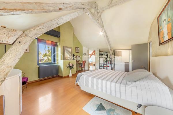 Une maison qui invite à ralentir…

Certaines propriétés séduisent par leurs prestations. 
D'autres procurent, dès les premiers instants, une sensation plus rare : celle de se sentir bien.

Ici, tout commence avant même d'ouvrir la porte.

Le jardin, entièrement aménagé au fil des années, ne cherche pas la perfection. 
Il est vivant, chaleureux, généreux. Les arbres ont grandi, les massifs se mêlent naturellement aux différents espaces de vie et chaque saison révèle une nouvelle palette de couleurs. C'est un jardin que l'on prend plaisir à parcourir, où l'on imagine les repas d'été, les après-midis au bord de la piscine ou tout simplement quelques instants de calme après une journée bien remplie.

Puis la maison se dévoile.

Ancienne longère entièrement rénovée, elle développe près de 230 m² habitables dans un équilibre réussi entre authenticité et confort contemporain. 
Difficile d'imaginer, en s'y installant, que les commerces, écoles et services sont accessibles en moins d'un kilomètre et que Rennes ne se trouve qu'à 15 minutes en voiture.

Le cœur de la maison est sans conteste sa magnifique pièce de vie sous plafond cathédrale. La lumière y entre généreusement grâce aux larges baies vitrées ouvertes sur le jardin, tandis que la charpente apparente rappelle avec élégance le caractère des lieux. (Pour vous aider à projeter votre futur intérieur, une proposition d'aménagement et de décoration virtuelle aux teintes naturelles est intégrée parmi les visuels.)

Pensée pour s'adapter à de nombreux projets de vie, la propriété s'organise autour de deux espaces communicants :

Le premier accueille une cuisine aménagée et équipée avec arrière-cuisine, un vaste salon-séjour, une chambre avec salle d'eau, une mezzanine aménagée en bureau ainsi qu'une suite parentale climatisée avec sa salle de bains.
Le second propose deux chambres, deux salles d'eau et un grand dortoir, offrant un confort idéal pour une grande famille, des adolescents en quête d'indépendance, l'accueil de proches ou encore un projet de chambres d'hôtes ou d’une profession libérale.

À l'extérieur, les 3 179 m² de terrain prolongent naturellement la maison. La piscine couverte s'intègre avec discrétion dans cet environnement verdoyant et permet d'en profiter bien au-delà de la belle saison.

Enfin, un élément mérite d'être souligné. Derrière le charme de cette demeure de caractère se cache une rénovation particulièrement aboutie. 
Son CLASSEMENT ÉNERGÉTIQUE B, rare pour une propriété des années 2000 et de cette superficie, témoigne d'un réel souci de conjuguer cachet, confort et performance énergétique. Pompe à chaleur, panneaux photovoltaïques et rénovation de qualité offrent aujourd'hui un confort de vie appréciable tout en répondant aux attentes de demain.

Cette maison ne se résume pas à ses volumes ou à ses prestations. 
C'est un lieu que l'on découvre, que l'on ressent… et dont il est difficile de repartir sans s'y projeter.