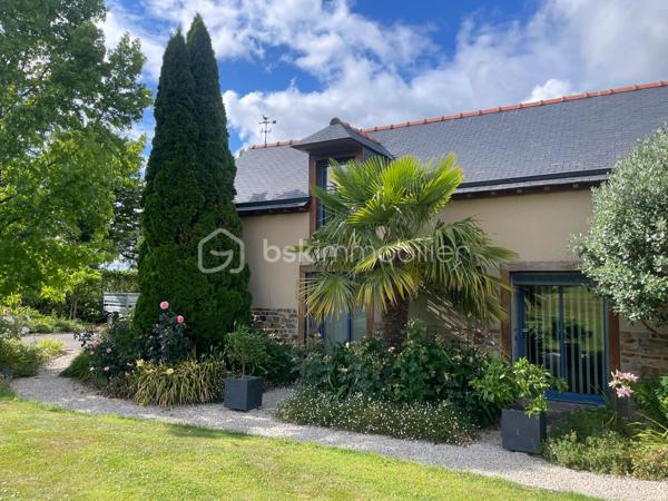 Une maison qui invite à ralentir…

Certaines propriétés séduisent par leurs prestations. 
D'autres procurent, dès les premiers instants, une sensation plus rare : celle de se sentir bien.

Ici, tout commence avant même d'ouvrir la porte.

Le jardin, entièrement aménagé au fil des années, ne cherche pas la perfection. 
Il est vivant, chaleureux, généreux. Les arbres ont grandi, les massifs se mêlent naturellement aux différents espaces de vie et chaque saison révèle une nouvelle palette de couleurs. C'est un jardin que l'on prend plaisir à parcourir, où l'on imagine les repas d'été, les après-midis au bord de la piscine ou tout simplement quelques instants de calme après une journée bien remplie.

Puis la maison se dévoile.

Ancienne longère entièrement rénovée, elle développe près de 230 m² habitables dans un équilibre réussi entre authenticité et confort contemporain. 
Difficile d'imaginer, en s'y installant, que les commerces, écoles et services sont accessibles en moins d'un kilomètre et que Rennes ne se trouve qu'à 15 minutes en voiture.

Le cœur de la maison est sans conteste sa magnifique pièce de vie sous plafond cathédrale. La lumière y entre généreusement grâce aux larges baies vitrées ouvertes sur le jardin, tandis que la charpente apparente rappelle avec élégance le caractère des lieux. (Pour vous aider à projeter votre futur intérieur, une proposition d'aménagement et de décoration virtuelle aux teintes naturelles est intégrée parmi les visuels.)

Pensée pour s'adapter à de nombreux projets de vie, la propriété s'organise autour de deux espaces communicants :

Le premier accueille une cuisine aménagée et équipée avec arrière-cuisine, un vaste salon-séjour, une chambre avec salle d'eau, une mezzanine aménagée en bureau ainsi qu'une suite parentale climatisée avec sa salle de bains.
Le second propose deux chambres, deux salles d'eau et un grand dortoir, offrant un confort idéal pour une grande famille, des adolescents en quête d'indépendance, l'accueil de proches ou encore un projet de chambres d'hôtes ou d’une profession libérale.

À l'extérieur, les 3 179 m² de terrain prolongent naturellement la maison. La piscine couverte s'intègre avec discrétion dans cet environnement verdoyant et permet d'en profiter bien au-delà de la belle saison.

Enfin, un élément mérite d'être souligné. Derrière le charme de cette demeure de caractère se cache une rénovation particulièrement aboutie. 
Son CLASSEMENT ÉNERGÉTIQUE B, rare pour une propriété des années 2000 et de cette superficie, témoigne d'un réel souci de conjuguer cachet, confort et performance énergétique. Pompe à chaleur, panneaux photovoltaïques et rénovation de qualité offrent aujourd'hui un confort de vie appréciable tout en répondant aux attentes de demain.

Cette maison ne se résume pas à ses volumes ou à ses prestations. 
C'est un lieu que l'on découvre, que l'on ressent… et dont il est difficile de repartir sans s'y projeter.