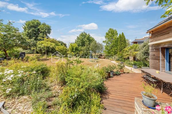 Une maison qui invite à ralentir…

Certaines propriétés séduisent par leurs prestations. 
D'autres procurent, dès les premiers instants, une sensation plus rare : celle de se sentir bien.

Ici, tout commence avant même d'ouvrir la porte.

Le jardin, entièrement aménagé au fil des années, ne cherche pas la perfection. 
Il est vivant, chaleureux, généreux. Les arbres ont grandi, les massifs se mêlent naturellement aux différents espaces de vie et chaque saison révèle une nouvelle palette de couleurs. C'est un jardin que l'on prend plaisir à parcourir, où l'on imagine les repas d'été, les après-midis au bord de la piscine ou tout simplement quelques instants de calme après une journée bien remplie.

Puis la maison se dévoile.

Ancienne longère entièrement rénovée, elle développe près de 230 m² habitables dans un équilibre réussi entre authenticité et confort contemporain. 
Difficile d'imaginer, en s'y installant, que les commerces, écoles et services sont accessibles en moins d'un kilomètre et que Rennes ne se trouve qu'à 15 minutes en voiture.

Le cœur de la maison est sans conteste sa magnifique pièce de vie sous plafond cathédrale. La lumière y entre généreusement grâce aux larges baies vitrées ouvertes sur le jardin, tandis que la charpente apparente rappelle avec élégance le caractère des lieux. (Pour vous aider à projeter votre futur intérieur, une proposition d'aménagement et de décoration virtuelle aux teintes naturelles est intégrée parmi les visuels.)

Pensée pour s'adapter à de nombreux projets de vie, la propriété s'organise autour de deux espaces communicants :

Le premier accueille une cuisine aménagée et équipée avec arrière-cuisine, un vaste salon-séjour, une chambre avec salle d'eau, une mezzanine aménagée en bureau ainsi qu'une suite parentale climatisée avec sa salle de bains.
Le second propose deux chambres, deux salles d'eau et un grand dortoir, offrant un confort idéal pour une grande famille, des adolescents en quête d'indépendance, l'accueil de proches ou encore un projet de chambres d'hôtes ou d’une profession libérale.

À l'extérieur, les 3 179 m² de terrain prolongent naturellement la maison. La piscine couverte s'intègre avec discrétion dans cet environnement verdoyant et permet d'en profiter bien au-delà de la belle saison.

Enfin, un élément mérite d'être souligné. Derrière le charme de cette demeure de caractère se cache une rénovation particulièrement aboutie. 
Son CLASSEMENT ÉNERGÉTIQUE B, rare pour une propriété des années 2000 et de cette superficie, témoigne d'un réel souci de conjuguer cachet, confort et performance énergétique. Pompe à chaleur, panneaux photovoltaïques et rénovation de qualité offrent aujourd'hui un confort de vie appréciable tout en répondant aux attentes de demain.

Cette maison ne se résume pas à ses volumes ou à ses prestations. 
C'est un lieu que l'on découvre, que l'on ressent… et dont il est difficile de repartir sans s'y projeter.
