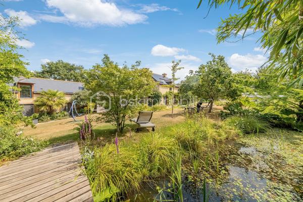 Une maison qui invite à ralentir…

Certaines propriétés séduisent par leurs prestations. 
D'autres procurent, dès les premiers instants, une sensation plus rare : celle de se sentir bien.

Ici, tout commence avant même d'ouvrir la porte.

Le jardin, entièrement aménagé au fil des années, ne cherche pas la perfection. 
Il est vivant, chaleureux, généreux. Les arbres ont grandi, les massifs se mêlent naturellement aux différents espaces de vie et chaque saison révèle une nouvelle palette de couleurs. C'est un jardin que l'on prend plaisir à parcourir, où l'on imagine les repas d'été, les après-midis au bord de la piscine ou tout simplement quelques instants de calme après une journée bien remplie.

Puis la maison se dévoile.

Ancienne longère entièrement rénovée, elle développe près de 230 m² habitables dans un équilibre réussi entre authenticité et confort contemporain. 
Difficile d'imaginer, en s'y installant, que les commerces, écoles et services sont accessibles en moins d'un kilomètre et que Rennes ne se trouve qu'à 15 minutes en voiture.

Le cœur de la maison est sans conteste sa magnifique pièce de vie sous plafond cathédrale. La lumière y entre généreusement grâce aux larges baies vitrées ouvertes sur le jardin, tandis que la charpente apparente rappelle avec élégance le caractère des lieux. (Pour vous aider à projeter votre futur intérieur, une proposition d'aménagement et de décoration virtuelle aux teintes naturelles est intégrée parmi les visuels.)

Pensée pour s'adapter à de nombreux projets de vie, la propriété s'organise autour de deux espaces communicants :

Le premier accueille une cuisine aménagée et équipée avec arrière-cuisine, un vaste salon-séjour, une chambre avec salle d'eau, une mezzanine aménagée en bureau ainsi qu'une suite parentale climatisée avec sa salle de bains.
Le second propose deux chambres, deux salles d'eau et un grand dortoir, offrant un confort idéal pour une grande famille, des adolescents en quête d'indépendance, l'accueil de proches ou encore un projet de chambres d'hôtes ou d’une profession libérale.

À l'extérieur, les 3 179 m² de terrain prolongent naturellement la maison. La piscine couverte s'intègre avec discrétion dans cet environnement verdoyant et permet d'en profiter bien au-delà de la belle saison.

Enfin, un élément mérite d'être souligné. Derrière le charme de cette demeure de caractère se cache une rénovation particulièrement aboutie. 
Son CLASSEMENT ÉNERGÉTIQUE B, rare pour une propriété des années 2000 et de cette superficie, témoigne d'un réel souci de conjuguer cachet, confort et performance énergétique. Pompe à chaleur, panneaux photovoltaïques et rénovation de qualité offrent aujourd'hui un confort de vie appréciable tout en répondant aux attentes de demain.

Cette maison ne se résume pas à ses volumes ou à ses prestations. 
C'est un lieu que l'on découvre, que l'on ressent… et dont il est difficile de repartir sans s'y projeter.