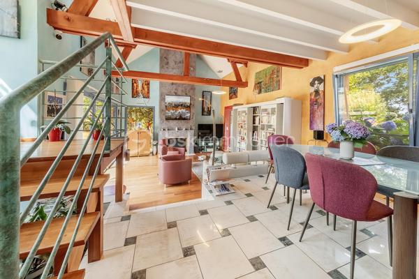 Une maison qui invite à ralentir…

Certaines propriétés séduisent par leurs prestations. 
D'autres procurent, dès les premiers instants, une sensation plus rare : celle de se sentir bien.

Ici, tout commence avant même d'ouvrir la porte.

Le jardin, entièrement aménagé au fil des années, ne cherche pas la perfection. 
Il est vivant, chaleureux, généreux. Les arbres ont grandi, les massifs se mêlent naturellement aux différents espaces de vie et chaque saison révèle une nouvelle palette de couleurs. C'est un jardin que l'on prend plaisir à parcourir, où l'on imagine les repas d'été, les après-midis au bord de la piscine ou tout simplement quelques instants de calme après une journée bien remplie.

Puis la maison se dévoile.

Ancienne longère entièrement rénovée, elle développe près de 230 m² habitables dans un équilibre réussi entre authenticité et confort contemporain. 
Difficile d'imaginer, en s'y installant, que les commerces, écoles et services sont accessibles en moins d'un kilomètre et que Rennes ne se trouve qu'à 15 minutes en voiture.

Le cœur de la maison est sans conteste sa magnifique pièce de vie sous plafond cathédrale. La lumière y entre généreusement grâce aux larges baies vitrées ouvertes sur le jardin, tandis que la charpente apparente rappelle avec élégance le caractère des lieux. (Pour vous aider à projeter votre futur intérieur, une proposition d'aménagement et de décoration virtuelle aux teintes naturelles est intégrée parmi les visuels.)

Pensée pour s'adapter à de nombreux projets de vie, la propriété s'organise autour de deux espaces communicants :

Le premier accueille une cuisine aménagée et équipée avec arrière-cuisine, un vaste salon-séjour, une chambre avec salle d'eau, une mezzanine aménagée en bureau ainsi qu'une suite parentale climatisée avec sa salle de bains.
Le second propose deux chambres, deux salles d'eau et un grand dortoir, offrant un confort idéal pour une grande famille, des adolescents en quête d'indépendance, l'accueil de proches ou encore un projet de chambres d'hôtes ou d’une profession libérale.

À l'extérieur, les 3 179 m² de terrain prolongent naturellement la maison. La piscine couverte s'intègre avec discrétion dans cet environnement verdoyant et permet d'en profiter bien au-delà de la belle saison.

Enfin, un élément mérite d'être souligné. Derrière le charme de cette demeure de caractère se cache une rénovation particulièrement aboutie. 
Son CLASSEMENT ÉNERGÉTIQUE B, rare pour une propriété des années 2000 et de cette superficie, témoigne d'un réel souci de conjuguer cachet, confort et performance énergétique. Pompe à chaleur, panneaux photovoltaïques et rénovation de qualité offrent aujourd'hui un confort de vie appréciable tout en répondant aux attentes de demain.

Cette maison ne se résume pas à ses volumes ou à ses prestations. 
C'est un lieu que l'on découvre, que l'on ressent… et dont il est difficile de repartir sans s'y projeter.