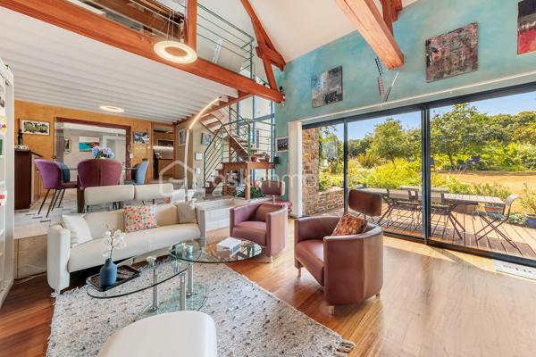 Une maison qui invite à ralentir…

Certaines propriétés séduisent par leurs prestations. 
D'autres procurent, dès les premiers instants, une sensation plus rare : celle de se sentir bien.

Ici, tout commence avant même d'ouvrir la porte.

Le jardin, entièrement aménagé au fil des années, ne cherche pas la perfection. 
Il est vivant, chaleureux, généreux. Les arbres ont grandi, les massifs se mêlent naturellement aux différents espaces de vie et chaque saison révèle une nouvelle palette de couleurs. C'est un jardin que l'on prend plaisir à parcourir, où l'on imagine les repas d'été, les après-midis au bord de la piscine ou tout simplement quelques instants de calme après une journée bien remplie.

Puis la maison se dévoile.

Ancienne longère entièrement rénovée, elle développe près de 230 m² habitables dans un équilibre réussi entre authenticité et confort contemporain. 
Difficile d'imaginer, en s'y installant, que les commerces, écoles et services sont accessibles en moins d'un kilomètre et que Rennes ne se trouve qu'à 15 minutes en voiture.

Le cœur de la maison est sans conteste sa magnifique pièce de vie sous plafond cathédrale. La lumière y entre généreusement grâce aux larges baies vitrées ouvertes sur le jardin, tandis que la charpente apparente rappelle avec élégance le caractère des lieux. (Pour vous aider à projeter votre futur intérieur, une proposition d'aménagement et de décoration virtuelle aux teintes naturelles est intégrée parmi les visuels.)

Pensée pour s'adapter à de nombreux projets de vie, la propriété s'organise autour de deux espaces communicants :

Le premier accueille une cuisine aménagée et équipée avec arrière-cuisine, un vaste salon-séjour, une chambre avec salle d'eau, une mezzanine aménagée en bureau ainsi qu'une suite parentale climatisée avec sa salle de bains.
Le second propose deux chambres, deux salles d'eau et un grand dortoir, offrant un confort idéal pour une grande famille, des adolescents en quête d'indépendance, l'accueil de proches ou encore un projet de chambres d'hôtes ou d’une profession libérale.

À l'extérieur, les 3 179 m² de terrain prolongent naturellement la maison. La piscine couverte s'intègre avec discrétion dans cet environnement verdoyant et permet d'en profiter bien au-delà de la belle saison.

Enfin, un élément mérite d'être souligné. Derrière le charme de cette demeure de caractère se cache une rénovation particulièrement aboutie. 
Son CLASSEMENT ÉNERGÉTIQUE B, rare pour une propriété des années 2000 et de cette superficie, témoigne d'un réel souci de conjuguer cachet, confort et performance énergétique. Pompe à chaleur, panneaux photovoltaïques et rénovation de qualité offrent aujourd'hui un confort de vie appréciable tout en répondant aux attentes de demain.

Cette maison ne se résume pas à ses volumes ou à ses prestations. 
C'est un lieu que l'on découvre, que l'on ressent… et dont il est difficile de repartir sans s'y projeter.