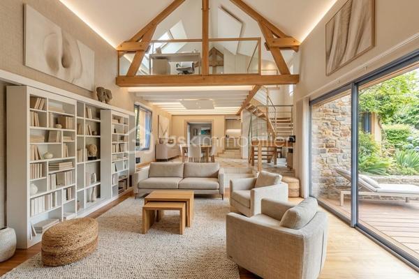 Une maison qui invite à ralentir…

Certaines propriétés séduisent par leurs prestations. 
D'autres procurent, dès les premiers instants, une sensation plus rare : celle de se sentir bien.

Ici, tout commence avant même d'ouvrir la porte.

Le jardin, entièrement aménagé au fil des années, ne cherche pas la perfection. 
Il est vivant, chaleureux, généreux. Les arbres ont grandi, les massifs se mêlent naturellement aux différents espaces de vie et chaque saison révèle une nouvelle palette de couleurs. C'est un jardin que l'on prend plaisir à parcourir, où l'on imagine les repas d'été, les après-midis au bord de la piscine ou tout simplement quelques instants de calme après une journée bien remplie.

Puis la maison se dévoile.

Ancienne longère entièrement rénovée, elle développe près de 230 m² habitables dans un équilibre réussi entre authenticité et confort contemporain. 
Difficile d'imaginer, en s'y installant, que les commerces, écoles et services sont accessibles en moins d'un kilomètre et que Rennes ne se trouve qu'à 15 minutes en voiture.

Le cœur de la maison est sans conteste sa magnifique pièce de vie sous plafond cathédrale. La lumière y entre généreusement grâce aux larges baies vitrées ouvertes sur le jardin, tandis que la charpente apparente rappelle avec élégance le caractère des lieux. (Pour vous aider à projeter votre futur intérieur, une proposition d'aménagement et de décoration virtuelle aux teintes naturelles est intégrée parmi les visuels.)

Pensée pour s'adapter à de nombreux projets de vie, la propriété s'organise autour de deux espaces communicants :

Le premier accueille une cuisine aménagée et équipée avec arrière-cuisine, un vaste salon-séjour, une chambre avec salle d'eau, une mezzanine aménagée en bureau ainsi qu'une suite parentale climatisée avec sa salle de bains.
Le second propose deux chambres, deux salles d'eau et un grand dortoir, offrant un confort idéal pour une grande famille, des adolescents en quête d'indépendance, l'accueil de proches ou encore un projet de chambres d'hôtes ou d’une profession libérale.

À l'extérieur, les 3 179 m² de terrain prolongent naturellement la maison. La piscine couverte s'intègre avec discrétion dans cet environnement verdoyant et permet d'en profiter bien au-delà de la belle saison.

Enfin, un élément mérite d'être souligné. Derrière le charme de cette demeure de caractère se cache une rénovation particulièrement aboutie. 
Son CLASSEMENT ÉNERGÉTIQUE B, rare pour une propriété des années 2000 et de cette superficie, témoigne d'un réel souci de conjuguer cachet, confort et performance énergétique. Pompe à chaleur, panneaux photovoltaïques et rénovation de qualité offrent aujourd'hui un confort de vie appréciable tout en répondant aux attentes de demain.

Cette maison ne se résume pas à ses volumes ou à ses prestations. 
C'est un lieu que l'on découvre, que l'on ressent… et dont il est difficile de repartir sans s'y projeter.