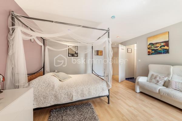 Une maison qui invite à ralentir…

Certaines propriétés séduisent par leurs prestations. 
D'autres procurent, dès les premiers instants, une sensation plus rare : celle de se sentir bien.

Ici, tout commence avant même d'ouvrir la porte.

Le jardin, entièrement aménagé au fil des années, ne cherche pas la perfection. 
Il est vivant, chaleureux, généreux. Les arbres ont grandi, les massifs se mêlent naturellement aux différents espaces de vie et chaque saison révèle une nouvelle palette de couleurs. C'est un jardin que l'on prend plaisir à parcourir, où l'on imagine les repas d'été, les après-midis au bord de la piscine ou tout simplement quelques instants de calme après une journée bien remplie.

Puis la maison se dévoile.

Ancienne longère entièrement rénovée, elle développe près de 230 m² habitables dans un équilibre réussi entre authenticité et confort contemporain. 
Difficile d'imaginer, en s'y installant, que les commerces, écoles et services sont accessibles en moins d'un kilomètre et que Rennes ne se trouve qu'à 15 minutes en voiture.

Le cœur de la maison est sans conteste sa magnifique pièce de vie sous plafond cathédrale. La lumière y entre généreusement grâce aux larges baies vitrées ouvertes sur le jardin, tandis que la charpente apparente rappelle avec élégance le caractère des lieux. (Pour vous aider à projeter votre futur intérieur, une proposition d'aménagement et de décoration virtuelle aux teintes naturelles est intégrée parmi les visuels.)

Pensée pour s'adapter à de nombreux projets de vie, la propriété s'organise autour de deux espaces communicants :

Le premier accueille une cuisine aménagée et équipée avec arrière-cuisine, un vaste salon-séjour, une chambre avec salle d'eau, une mezzanine aménagée en bureau ainsi qu'une suite parentale climatisée avec sa salle de bains.
Le second propose deux chambres, deux salles d'eau et un grand dortoir, offrant un confort idéal pour une grande famille, des adolescents en quête d'indépendance, l'accueil de proches ou encore un projet de chambres d'hôtes ou d’une profession libérale.

À l'extérieur, les 3 179 m² de terrain prolongent naturellement la maison. La piscine couverte s'intègre avec discrétion dans cet environnement verdoyant et permet d'en profiter bien au-delà de la belle saison.

Enfin, un élément mérite d'être souligné. Derrière le charme de cette demeure de caractère se cache une rénovation particulièrement aboutie. 
Son CLASSEMENT ÉNERGÉTIQUE B, rare pour une propriété des années 2000 et de cette superficie, témoigne d'un réel souci de conjuguer cachet, confort et performance énergétique. Pompe à chaleur, panneaux photovoltaïques et rénovation de qualité offrent aujourd'hui un confort de vie appréciable tout en répondant aux attentes de demain.

Cette maison ne se résume pas à ses volumes ou à ses prestations. 
C'est un lieu que l'on découvre, que l'on ressent… et dont il est difficile de repartir sans s'y projeter.