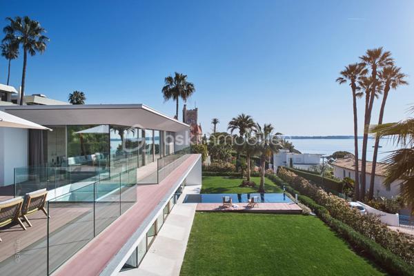 Nichée au cœur de l’un des domaines privés les plus prisés de Cannes, à deux pas du littoral, cette somptueuse villa contemporaine conjugue avec élégance luxe, design et quiétude.

Inspirée par l’architecture californienne, la propriété développe environ 500 m² habitables sur un terrain paysagé de 2245 m², offrant une vue imprenable sur la mer et l’île Sainte-Marguerite. De larges baies vitrées laissent généreusement entrer la lumière, effaçant les frontières entre intérieur et extérieur.

Distribution idéale sur plusieurs niveaux :

Rez-de-chaussée : hall d’entrée raffiné, toilettes invités, vaste séjour, salle à manger lumineuse, cuisine haut de gamme avec arrière-cuisine, deux chambres avec salles d’eau attenantes

Étage : spectaculaire suite parentale avec dressing et salle de bains, deux autres chambres en suite avec salles de douches privatives

Sous-sol : garage pour 4 véhicules, salon TV, hammam, salle de sport entièrement équipée, buanderie, toilettes, chambre de service avec salle de douche, et salle de massage

Cette propriété d’exception bénéficie également :

d’un ascenseur desservant tous les étages

d’une climatisation centralisée

d’une piscine à débordement chauffée à effet miroir

Son architecture aux lignes épurées, ses volumes généreux et ses prestations haut de gamme incarnent l’art de vivre californien au cœur de la Côte d’Azur.

Photos complémentaires sur demande

ENGLISH – Contemporary Sea View Villa – Private Estate in Cannes
Set in one of Cannes' most exclusive private estates, just steps from the coastline, this stunning contemporary villa offers a rare blend of luxury, modern design, and absolute serenity.

Inspired by Californian architecture, the residence boasts approximately 500 sqm of living space on a beautifully landscaped 2245 sqm plot, with breathtaking views over the sea and the Sainte-Marguerite Island. Floor-to-ceiling windows flood the interiors with natural light, creating a seamless connection between indoor and outdoor living.

Thoughtfully designed across several levels:

Ground floor: elegant entrance hall, guest WC, spacious living room, bright dining area, fully fitted kitchen with utility room, two en-suite bedrooms

First floor: luxurious master suite with walk-in wardrobe and en-suite bathroom, plus two additional en-suite bedrooms

Lower level: garage for up to 4 cars, TV lounge, hammam, fully equipped gym, laundry room, additional WC, staff bedroom with shower room, and a private massage room

The villa also features:

a lift serving all floors

central air conditioning

a heated infinity mirror pool

With its clean architectural lines, expansive sunlit interiors, and refined finishes, this home perfectly embodies the Californian lifestyle on the French Riviera.

Additional photos available on request