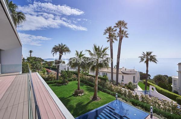 Nichée au cœur de l’un des domaines privés les plus prisés de Cannes, à deux pas du littoral, cette somptueuse villa contemporaine conjugue avec élégance luxe, design et quiétude.

Inspirée par l’architecture californienne, la propriété développe environ 500 m² habitables sur un terrain paysagé de 2245 m², offrant une vue imprenable sur la mer et l’île Sainte-Marguerite. De larges baies vitrées laissent généreusement entrer la lumière, effaçant les frontières entre intérieur et extérieur.

Distribution idéale sur plusieurs niveaux :

Rez-de-chaussée : hall d’entrée raffiné, toilettes invités, vaste séjour, salle à manger lumineuse, cuisine haut de gamme avec arrière-cuisine, deux chambres avec salles d’eau attenantes

Étage : spectaculaire suite parentale avec dressing et salle de bains, deux autres chambres en suite avec salles de douches privatives

Sous-sol : garage pour 4 véhicules, salon TV, hammam, salle de sport entièrement équipée, buanderie, toilettes, chambre de service avec salle de douche, et salle de massage

Cette propriété d’exception bénéficie également :

d’un ascenseur desservant tous les étages

d’une climatisation centralisée

d’une piscine à débordement chauffée à effet miroir

Son architecture aux lignes épurées, ses volumes généreux et ses prestations haut de gamme incarnent l’art de vivre californien au cœur de la Côte d’Azur.

Photos complémentaires sur demande

ENGLISH – Contemporary Sea View Villa – Private Estate in Cannes
Set in one of Cannes' most exclusive private estates, just steps from the coastline, this stunning contemporary villa offers a rare blend of luxury, modern design, and absolute serenity.

Inspired by Californian architecture, the residence boasts approximately 500 sqm of living space on a beautifully landscaped 2245 sqm plot, with breathtaking views over the sea and the Sainte-Marguerite Island. Floor-to-ceiling windows flood the interiors with natural light, creating a seamless connection between indoor and outdoor living.

Thoughtfully designed across several levels:

Ground floor: elegant entrance hall, guest WC, spacious living room, bright dining area, fully fitted kitchen with utility room, two en-suite bedrooms

First floor: luxurious master suite with walk-in wardrobe and en-suite bathroom, plus two additional en-suite bedrooms

Lower level: garage for up to 4 cars, TV lounge, hammam, fully equipped gym, laundry room, additional WC, staff bedroom with shower room, and a private massage room

The villa also features:

a lift serving all floors

central air conditioning

a heated infinity mirror pool

With its clean architectural lines, expansive sunlit interiors, and refined finishes, this home perfectly embodies the Californian lifestyle on the French Riviera.

Additional photos available on request