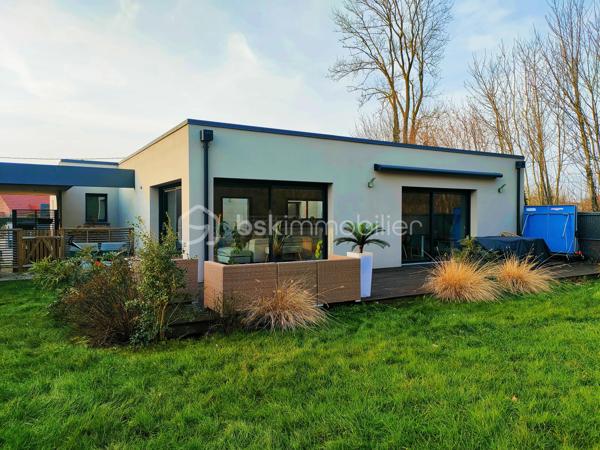 Coup de cœur assuré à Annoeullin !

Dans un environnement paisible et verdoyant, au sein d’une résidence privée, venez découvrir cette jolie maison cubique individuelle de plain-pied, construite en 2019, développant 178 m² habitables sur une parcelle de 700 m².

Dès l’entrée, vous serez séduit par ses beaux volumes et sa luminosité. La maison dispose d’une grande entrée avec dressing, qui dessert une vaste pièce de vie de plus de 70 m², comprenant un séjour ouvert sur une jolie cuisine équipée. Une buanderie et un WC indépendant complètent cet espace.

La partie nuit se compose d’une belle suite parentale de 21 m², avec dressing et salle de douche, ainsi que de trois chambres supplémentaires de 14,5 m², 14 m² et 13 m² et d’une salle de bains.

Véritable atout de cette maison, le patio de 35 m² est un espace rare dans notre secteur. Accessible directement depuis la pièce de vie ainsi que depuis deux des chambres, il apporte une ouverture agréable vers l’extérieur et crée un espace intimiste au cœur de la maison.

À l’extérieur, vous profiterez également d’un beau jardin exposé plein sud, avec une agréable vue dégagée sur la forêt.

La propriété dispose d’un garage, d’un double carport ainsi que de plusieurs places de stationnement privatives. L’ensemble de la parcelle est clos et accessible par un portail motorisé.

La maison est équipée d’un chauffage au sol, d’une VMC double flux et d’un adoucisseur.

À proximité de toutes les commodités : écoles, pharmacie, boulangerie, commerces et transports en commun, ainsi que des principaux axes autoroutiers.