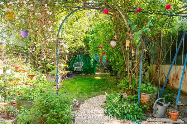 Maison avec dépendance et atelier autour d’un jardin arboré