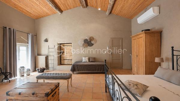 MAS XVIIIᵉ EN PIERRE • 340 M² • 8 CHAMBRES • PISCINE CHAUFFÉE • DRÔME PROVENÇALE

Au cœur de la Drôme provençale, entre Grignan et Dieulefit, découvrez ce remarquable mas en pierre datant du XVIIIᵉ siècle, restauré dans le respect de son authenticité et développant environ 340 m² habitables.

Organisé en L autour d'une ravissante cour intérieure d'environ 93 m², véritable cœur du mas, l'ensemble bénéficie d'une configuration particulièrement intéressante permettant de recevoir famille, amis ou hôtes tout en préservant l'intimité de chacun.

Une première aile accueille l'habitation principale. Depuis une belle terrasse bénéficiant d'une vue remarquable sur les paysages environnants, l'entrée ouvre sur une généreuse pièce de vie avec cuisine ouverte de 52,89 m².

Elle se prolonge par une suite parentale, une seconde chambre disposant de sa baignoire ainsi qu'une troisième chambre aménagée sous pente. Un grenier complète cette partie.

Dans l'autre aile, l'atmosphère se fait particulièrement chaleureuse avec un salon équipé d'un poêle à bois, prolongé par une salle à manger où l'ancienne mangeoire en pierre, soigneusement conservée, rappelle l'histoire et la vocation originelle des lieux.

Une arrière-cuisine ainsi qu'une cave à vin de 21,13 m² complètent ce niveau.

À l'étage, deux chambres disposent chacune de leur salle d'eau privative.

Côté cour et piscine, trois chambres supplémentaires bénéficient chacune de leur propre espace d'eau avec douche ou baignoire, offrant une belle indépendance à leurs occupants.

Le mas totalise ainsi 8 chambres et une capacité d'accueil particulièrement appréciable, avec une distribution adaptée aussi bien à une vie familiale qu'à une activité d'hébergement.

La rénovation a su préserver toute l'âme du bâti ancien : pierres et poutres apparentes, tomettes, pierres de taille, volumes généreux et éléments d'origine composent une atmosphère authentique, associée au confort actuel.

À l'extérieur, le mas est implanté sur environ 6 200 m² de terrain plat et arboré, dans un cadre préservé, sans voisinage immédiat et largement ouvert sur la campagne environnante.

Terrasses, espaces ombragés et perspectives dégagées invitent à profiter pleinement des lieux au fil des saisons.
La piscine chauffée et sécurisée de 5 × 10 m constitue un véritable espace de détente.

Un terrain de pétanque, un puits, un abri double pour deux véhicules, un vaste espace de stationnement ainsi que différentes annexes viennent compléter l’ensemble.
Par ses volumes, sa capacité d'accueil et son organisation permettant de préserver plusieurs univers de vie, ce mas se prête aussi bien à une grande maison de famille en résidence principale ou secondaire, qu'à un projet de location saisonnière, chambres d'hôtes ou gîtes.

Une propriété de caractère à la configuration rare, destinée aux amateurs de vieilles pierres et de lieux ayant conservé une véritable identité, dans un secteur privilégié de la Drôme provençale.

Informations et visites : contactez L’Immo By Céline PASCAL au 06 63 10 02 35.