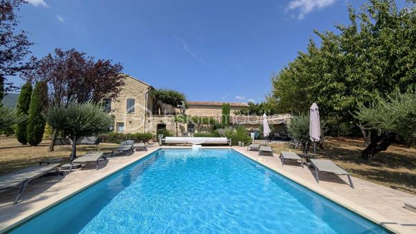 MAS XVIIIᵉ EN PIERRE • 340 M² • 8 CHAMBRES • PISCINE CHAUFFÉE • DRÔME PROVENÇALE

Au cœur de la Drôme provençale, entre Grignan et Dieulefit, découvrez ce remarquable mas en pierre datant du XVIIIᵉ siècle, restauré dans le respect de son authenticité et développant environ 340 m² habitables.

Organisé en L autour d'une ravissante cour intérieure d'environ 93 m², véritable cœur du mas, l'ensemble bénéficie d'une configuration particulièrement intéressante permettant de recevoir famille, amis ou hôtes tout en préservant l'intimité de chacun.

Une première aile accueille l'habitation principale. Depuis une belle terrasse bénéficiant d'une vue remarquable sur les paysages environnants, l'entrée ouvre sur une généreuse pièce de vie avec cuisine ouverte de 52,89 m².

Elle se prolonge par une suite parentale, une seconde chambre disposant de sa baignoire ainsi qu'une troisième chambre aménagée sous pente. Un grenier complète cette partie.

Dans l'autre aile, l'atmosphère se fait particulièrement chaleureuse avec un salon équipé d'un poêle à bois, prolongé par une salle à manger où l'ancienne mangeoire en pierre, soigneusement conservée, rappelle l'histoire et la vocation originelle des lieux.

Une arrière-cuisine ainsi qu'une cave à vin de 21,13 m² complètent ce niveau.

À l'étage, deux chambres disposent chacune de leur salle d'eau privative.

Côté cour et piscine, trois chambres supplémentaires bénéficient chacune de leur propre espace d'eau avec douche ou baignoire, offrant une belle indépendance à leurs occupants.

Le mas totalise ainsi 8 chambres et une capacité d'accueil particulièrement appréciable, avec une distribution adaptée aussi bien à une vie familiale qu'à une activité d'hébergement.

La rénovation a su préserver toute l'âme du bâti ancien : pierres et poutres apparentes, tomettes, pierres de taille, volumes généreux et éléments d'origine composent une atmosphère authentique, associée au confort actuel.

À l'extérieur, le mas est implanté sur environ 6 200 m² de terrain plat et arboré, dans un cadre préservé, sans voisinage immédiat et largement ouvert sur la campagne environnante.

Terrasses, espaces ombragés et perspectives dégagées invitent à profiter pleinement des lieux au fil des saisons.
La piscine chauffée et sécurisée de 5 × 10 m constitue un véritable espace de détente.

Un terrain de pétanque, un puits, un abri double pour deux véhicules, un vaste espace de stationnement ainsi que différentes annexes viennent compléter l’ensemble.
Par ses volumes, sa capacité d'accueil et son organisation permettant de préserver plusieurs univers de vie, ce mas se prête aussi bien à une grande maison de famille en résidence principale ou secondaire, qu'à un projet de location saisonnière, chambres d'hôtes ou gîtes.

Une propriété de caractère à la configuration rare, destinée aux amateurs de vieilles pierres et de lieux ayant conservé une véritable identité, dans un secteur privilégié de la Drôme provençale.

Informations et visites : contactez L’Immo By Céline PASCAL au 06 63 10 02 35.