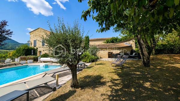 MAS XVIIIᵉ EN PIERRE • 340 M² • 8 CHAMBRES • PISCINE CHAUFFÉE • DRÔME PROVENÇALE

Au cœur de la Drôme provençale, entre Grignan et Dieulefit, découvrez ce remarquable mas en pierre datant du XVIIIᵉ siècle, restauré dans le respect de son authenticité et développant environ 340 m² habitables.

Organisé en L autour d'une ravissante cour intérieure d'environ 93 m², véritable cœur du mas, l'ensemble bénéficie d'une configuration particulièrement intéressante permettant de recevoir famille, amis ou hôtes tout en préservant l'intimité de chacun.

Une première aile accueille l'habitation principale. Depuis une belle terrasse bénéficiant d'une vue remarquable sur les paysages environnants, l'entrée ouvre sur une généreuse pièce de vie avec cuisine ouverte de 52,89 m².

Elle se prolonge par une suite parentale, une seconde chambre disposant de sa baignoire ainsi qu'une troisième chambre aménagée sous pente. Un grenier complète cette partie.

Dans l'autre aile, l'atmosphère se fait particulièrement chaleureuse avec un salon équipé d'un poêle à bois, prolongé par une salle à manger où l'ancienne mangeoire en pierre, soigneusement conservée, rappelle l'histoire et la vocation originelle des lieux.

Une arrière-cuisine ainsi qu'une cave à vin de 21,13 m² complètent ce niveau.

À l'étage, deux chambres disposent chacune de leur salle d'eau privative.

Côté cour et piscine, trois chambres supplémentaires bénéficient chacune de leur propre espace d'eau avec douche ou baignoire, offrant une belle indépendance à leurs occupants.

Le mas totalise ainsi 8 chambres et une capacité d'accueil particulièrement appréciable, avec une distribution adaptée aussi bien à une vie familiale qu'à une activité d'hébergement.

La rénovation a su préserver toute l'âme du bâti ancien : pierres et poutres apparentes, tomettes, pierres de taille, volumes généreux et éléments d'origine composent une atmosphère authentique, associée au confort actuel.

À l'extérieur, le mas est implanté sur environ 6 200 m² de terrain plat et arboré, dans un cadre préservé, sans voisinage immédiat et largement ouvert sur la campagne environnante.

Terrasses, espaces ombragés et perspectives dégagées invitent à profiter pleinement des lieux au fil des saisons.
La piscine chauffée et sécurisée de 5 × 10 m constitue un véritable espace de détente.

Un terrain de pétanque, un puits, un abri double pour deux véhicules, un vaste espace de stationnement ainsi que différentes annexes viennent compléter l’ensemble.
Par ses volumes, sa capacité d'accueil et son organisation permettant de préserver plusieurs univers de vie, ce mas se prête aussi bien à une grande maison de famille en résidence principale ou secondaire, qu'à un projet de location saisonnière, chambres d'hôtes ou gîtes.

Une propriété de caractère à la configuration rare, destinée aux amateurs de vieilles pierres et de lieux ayant conservé une véritable identité, dans un secteur privilégié de la Drôme provençale.

Informations et visites : contactez L’Immo By Céline PASCAL au 06 63 10 02 35.