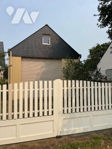 Terrain à bâtir sur lequel existe un garage et un clôture.

