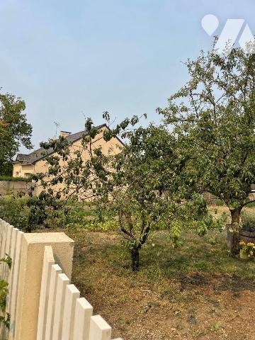 Terrain à bâtir sur lequel existe un garage et un clôture.

