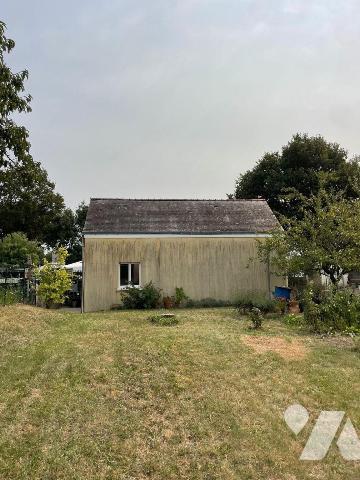 Terrain à bâtir sur lequel existe un garage et un clôture.


