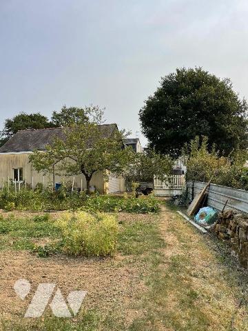 Terrain à bâtir sur lequel existe un garage et un clôture.

