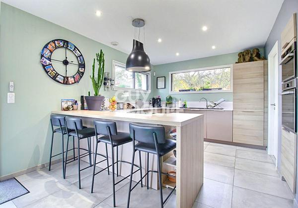 Maison contemporaine avec piscine chauffée et garage.