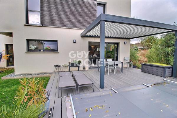 Maison contemporaine avec piscine chauffée et garage.