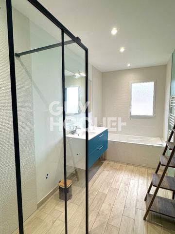 Maison contemporaine avec piscine chauffée et garage.