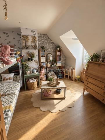 À Gasny (Eure, 27), au calme dans une impasse, cette maison lumineuse de 104 m² développe quatre chambres réparties sur deux niveaux, sur un terrain de 900 m². Grande pièce de vie avec cheminée à insert, chambre de plain-pied avec salle d'eau attenante, sous-sol total et terrasse composent un ensemble familial fonctionnel et bien agencé.

REZ-DE-CHAUSSÉE

La grande pièce de vie s'ouvre sur la cuisine, formant un espace unifié et lumineux, adapté aux moments du quotidien comme à la réception. Une cheminée à insert apporte chaleur et caractère à cet espace, tout en constituant un complément de chauffage appréciable en hiver. Ce niveau accueille également une chambre donnant sur une salle d'eau, configuration proche d'une suite qui permet une organisation de plain-pied, idéale pour des parents, des invités ou un usage sur le long terme. Un WC séparé complète le rez-de-chaussée, ainsi qu'un accès direct au sous-sol depuis l'intérieur.

À L'ÉTAGE

Un palier dessert trois chambres de bonne taille ainsi qu'une salle de bain avec toilettes. L'espace nuit de l'étage est ainsi clairement séparé des pièces de vie, avec des sanitaires présents à chaque niveau, une organisation pratique pour une famille avec enfants ou un foyer souhaitant dédier une pièce au télétravail.

SOUS-SOL TOTAL

Le grand sous-sol total, accessible depuis l'intérieur, bénéficie d'une bonne hauteur. Il offre un volume conséquent en complément de la surface habitable, utilisable en rangement, atelier, buanderie ou stationnement selon les besoins. Un atout concret, qui élargit sensiblement les possibilités d'usage du bien au quotidien.

EXTÉRIEUR

Le terrain de 900 m² offre un espace extérieur généreux, propice aux activités familiales, à l'aménagement paysager ou à un potager. Une terrasse prolonge la maison et permet de profiter des beaux jours en continuité avec les pièces de vie. Le terrain est sans vis-à-vis, ce qui garantit une vraie intimité dans l'usage de l'extérieur.

ENVIRONNEMENT ET ACCÈS

L'implantation en impasse assure une tranquillité réelle, avec une circulation limitée aux seuls riverains, un critère recherché par les familles, notamment pour la sécurité des enfants. Gasny se situe dans l'Eure, à proximité de Vernon et de la vallée de la Seine, dans un cadre verdoyant qui reste relié aux commerces, établissements scolaires et axes routiers du secteur.

POINTS À NOTER

Cette maison s'adresse aux familles recherchant un bien lumineux et fonctionnel, avec quatre chambres dont une de plain-pied, un sous-sol total et un grand terrain, dans un environnement calme.

Une maison familiale lumineuse de 104 m², avec sous-sol total et terrain de 900 m², au calme en impasse à Gasny.