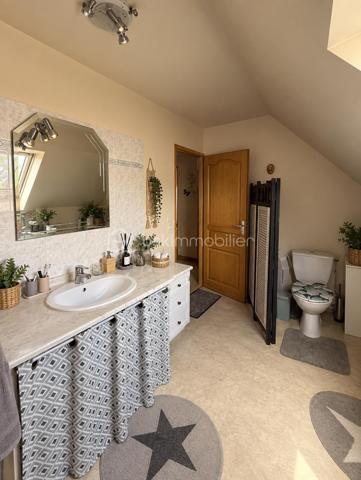 À Gasny (Eure, 27), au calme dans une impasse, cette maison lumineuse de 104 m² développe quatre chambres réparties sur deux niveaux, sur un terrain de 900 m². Grande pièce de vie avec cheminée à insert, chambre de plain-pied avec salle d'eau attenante, sous-sol total et terrasse composent un ensemble familial fonctionnel et bien agencé.

REZ-DE-CHAUSSÉE

La grande pièce de vie s'ouvre sur la cuisine, formant un espace unifié et lumineux, adapté aux moments du quotidien comme à la réception. Une cheminée à insert apporte chaleur et caractère à cet espace, tout en constituant un complément de chauffage appréciable en hiver. Ce niveau accueille également une chambre donnant sur une salle d'eau, configuration proche d'une suite qui permet une organisation de plain-pied, idéale pour des parents, des invités ou un usage sur le long terme. Un WC séparé complète le rez-de-chaussée, ainsi qu'un accès direct au sous-sol depuis l'intérieur.

À L'ÉTAGE

Un palier dessert trois chambres de bonne taille ainsi qu'une salle de bain avec toilettes. L'espace nuit de l'étage est ainsi clairement séparé des pièces de vie, avec des sanitaires présents à chaque niveau, une organisation pratique pour une famille avec enfants ou un foyer souhaitant dédier une pièce au télétravail.

SOUS-SOL TOTAL

Le grand sous-sol total, accessible depuis l'intérieur, bénéficie d'une bonne hauteur. Il offre un volume conséquent en complément de la surface habitable, utilisable en rangement, atelier, buanderie ou stationnement selon les besoins. Un atout concret, qui élargit sensiblement les possibilités d'usage du bien au quotidien.

EXTÉRIEUR

Le terrain de 900 m² offre un espace extérieur généreux, propice aux activités familiales, à l'aménagement paysager ou à un potager. Une terrasse prolonge la maison et permet de profiter des beaux jours en continuité avec les pièces de vie. Le terrain est sans vis-à-vis, ce qui garantit une vraie intimité dans l'usage de l'extérieur.

ENVIRONNEMENT ET ACCÈS

L'implantation en impasse assure une tranquillité réelle, avec une circulation limitée aux seuls riverains, un critère recherché par les familles, notamment pour la sécurité des enfants. Gasny se situe dans l'Eure, à proximité de Vernon et de la vallée de la Seine, dans un cadre verdoyant qui reste relié aux commerces, établissements scolaires et axes routiers du secteur.

POINTS À NOTER

Cette maison s'adresse aux familles recherchant un bien lumineux et fonctionnel, avec quatre chambres dont une de plain-pied, un sous-sol total et un grand terrain, dans un environnement calme.

Une maison familiale lumineuse de 104 m², avec sous-sol total et terrain de 900 m², au calme en impasse à Gasny.