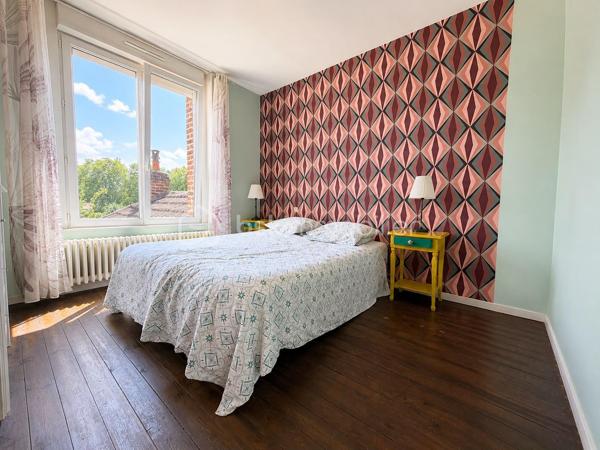 Située dans le quartier du Faubourg d'Isle à Saint-Quentin, cette charmante maison semi-mitoyenne des années 1930 de 107 m² saura séduire les familles à la recherche d'espace, de confort et de praticité.

Dès l'entrée, vous découvrirez un vaste salon-séjour de plus de 30 m², chaleureux et convivial, agrémenté d'un poêle à granulés. Dans son prolongement, une cuisine aménagée et équipée offre un espace fonctionnel pour le quotidien.

Le rez-de-chaussée dispose également d'une pièce polyvalente pouvant servir de bureau, ou d'espace de télétravail. Celle-ci dessert une salle d'eau avec douche, des WC indépendants ainsi qu'un accès direct au garage d'environ 40m² qui peut-être aménagé.

À l'étage, un palier distribue deux belles chambres ainsi qu'un dressing indépendant. Le second étage accueille une grande chambre de plus de 20 m² habitables (environ 30 m² au sol), idéale pour une chambre d'adolescent ou un espace de loisirs.

À l'extérieur, vous profiterez d'un agréable jardin accessible par deux accès donnant chacun sur une terrasse, parfait pour profiter des beaux jours. Plusieurs dépendances complètent les prestations et offrent de nombreuses possibilités de rangement ou d'aménagement. Une cave vient également compléter le bien.

Les principaux atouts :

- Grand salon-séjour.
- Bureau ou chambre d'appoint au rez-de-chaussée.
- Trois chambres, dont une grande chambre de plus de 20 m² habitables.
- Jardin avec deux terrasses.
- Garage de 39m².
- Dépendances et cave.
- Plusieurs modes de chauffage : poêle à granulés, poêle à bois et chauffage central au gaz.
- Menuiseries PVC avec volets roulants électriques.

Un emplacement pratique au quotidien

À proximité immédiate des écoles, commerces, gare, transports en commun et des principaux axes routiers, cette maison offre un cadre de vie agréable tout en facilitant les déplacements. Une opportunité idéale pour une famille souhaitant s'installer dans un secteur apprécié de Saint-Quentin.

À visiter sans tarder !