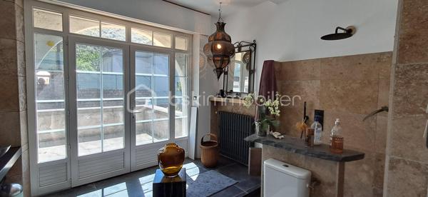 Aux pieds des Cévennes, nichée sur les hauteurs, cette superbe demeure allie harmonie charme, élégance et authenticité. Baignée de lumière, elle vous offre une vue dégagée ainsi qu'un cadre de vie privilégié, propice à la douceur de vivre. Elle est à deux pas de toutes les commodités. 247 m² sur 2 niveaux (plus combles et rez-de-jardin), cette maison vous propose de beaux volumes avec sa pièce de vie de 100 m² environ, cuisine ouverte, salon, espace détente, ouvrant sur l'extérieur, sur la piscine également (8 m x 4 m profondeur 1,5 m, avec douche et WC). La partie nuit se compose de 6 chambres, idéales pour accueillir et recevoir en toute sérénité. 1 salle d'eau avec WC au niveau 1 et 1 salle de bains avec WC séparé au niveau 2. Buanderie. Vous avez la possibilité de transformer les espaces du niveau 0 à votre guise, studio, atelier, sauna... ainsi que les combles. Pompe à chaleur, double vitrage, fibre, toiture en bon état. Le terrain en restanques de 1610 m², soigneusement aménagé vous offre de beaux espaces vous invitant à la détente dans un environnement préservé. Portail électrique, 2 garages. Propriété de caractère offrant espace, confort, au pieds de nos belles Cévennes, dans une atmosphère rare. Contactez moi, j'ai hâte de vous la faire découvrir !
At the foothills of the Cévennes, perched on elevated ground, this magnificent property combines charm, elegance, harmony, and authenticity. Bathed in natural light, it offers open views and an exceptional living environment, ideal for a peaceful lifestyle. Conveniently located just moments from all amenities, this 247 m² home is spread over two levels (plus attic space and a garden level). The house features generous living spaces, including an approximately 100 m² open-plan living area with a kitchen, lounge, and relaxation space opening directly onto the outdoors and the swimming pool (8 m x 4 m, 1.5 m deep, with an outdoor shower and WC). The sleeping area comprises six bedrooms, perfect for accommodating family and guests in complete comfort. There is one shower room with WC on the first level and one bathroom with a separate WC on the second level. A laundry room is also included. The garden-level spaces can be adapted to suit your needs and could be transformed into a studio, workshop, sauna, or other leisure areas, as can the attic space. The property benefits from a heat pump, double glazing, fibre-optic internet, and a roof in good condition. The beautifully landscaped 1,610 m² terraced plot offers attractive outdoor spaces dedicated to relaxation in a preserved natural setting. Additional features include an electric gate and two garages. A character-filled property offering space, comfort, and tranquillity at the foot of the beautiful Cévennes Mountains, in a truly unique atmosphere. Contact me today—I would be delighted to show you this exceptional home.