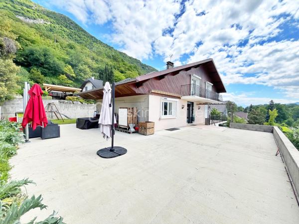Idéalement située à Challes-les-Eaux, dans un environnement particulièrement recherché, au calme absolu au fond d’une impasse et à seulement à quelques minutes à pied du centre-ville, cette belle maison familiale saura séduire les amateurs d’espace, de tranquillité et de confort.

Édifiée sur un terrain de 680 m², cette maison développe 174 m² habitables (290 m² au sol) répartis sur trois niveaux, offrant de beaux volumes et une organisation idéale pour une grande famille.

Dès l’entrée, vous découvrirez une maison lumineuse bénéficiant d’une agréable exposition sud-ouest ainsi que d’une belle vue dégagée. Les espaces de vie profitent d’un accès direct aux grands balcons et à la terrasse exposés ouest, parfaits pour profiter des fins de journée ensoleillées.

L’agencement intérieur a été pensé pour offrir confort et fonctionnalité avec cinq grandes chambres, dont une véritable suite parentale au RDC comprenant dressing et salle de bains privative — un atout rare et particulièrement recherché. Des WC indépendants sont présents à chaque niveau ainsi qu'une salle d'eau à l'étage.

À l’extérieur, la maison offre différents espaces de vie permettant de profiter pleinement de chaque moment de la journée, avec un agréable coin jardin côté est.

Construite dans les années 70 et parfaitement entretenue, cette maison bénéficie de prestations de confort appréciables avec des menuiseries PVC en triple vitrage et des volets roulants électriques, garantissant confort thermique et tranquillité au quotidien. Elle est également équipée d’un chauffage performant aux granulés de bois (pellets), lui permettant d’obtenir un excellent classement énergétique (DPE C).

Un sous-sol total complète ces prestations avec de vastes espaces de stockage, une cave, un grand garage ainsi que des stationnements extérieur.

Son emplacement constitue un véritable point fort : située derrière le parc des Thermes, elle permet un accès rapide aux commodités, écoles, commerces et axes principaux tout en conservant un environnement résidentiel paisible.

Une maison aux volumes généreux et à l’emplacement privilégié, idéale pour une famille à la recherche d’espace et de qualité de vie.

Contactez moi si vous souhaitez organiser une visite.