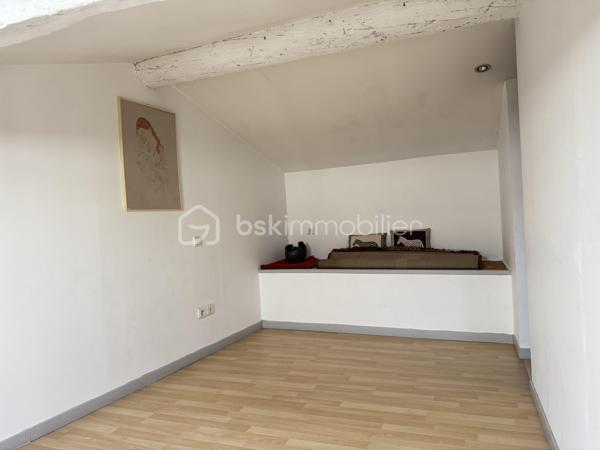 Situé dans une maison de ville en pierre divisée en seulement deux lots, cet appartement bénéficie de l'esprit et de l'indépendance d'une maison de ville. Ses beaux volumes, son cachet authentique et sa grande terrasse en font un bien rare, idéal pour une vie de famille confortable.

Dès l'entrée, vous apprécierez les nombreux espaces de rangement astucieusement aménagés, avec un débarras créé dans une ancienne cuve ainsi qu'un espace de stockage sous l'escalier. Le premier étage accueille une agréable pièce de vie lumineuse comprenant un séjour convivial et une cuisine aménagée et équipée. Cet espace s'ouvre directement sur une terrasse d'environ 16 m², parfaite pour profiter des beaux jours en toute tranquillité.

L'espace nuit principal se compose de deux belles chambres d'environ 16 m² et 15 m², dont une dispose d'un placard intégré. Une salle de bain équipée d'une baignoire et d'une douche, un WC indépendant ainsi qu'une buanderie complètent ce niveau particulièrement fonctionnel.

Au second étage, vous découvrirez une vaste pièce pouvant être aménagée selon vos besoins en chambre supplémentaire, salle de jeux ou espace de loisirs. Une mezzanine vient compléter cet étage et pourra accueillir un bureau, un coin détente ou un couchage d'appoint. Les espaces mansardés apportent beaucoup de charme et de caractère à l'ensemble.

Côté confort, le bien bénéficie de prestations appréciables avec une climatisation réversible dans le séjour, le double vitrage, des volets roulants électriques sur la majorité des ouvertures, la fibre optique installée ainsi qu'un visiophone. Les peintures ont été récemment refaites et le cumulus est récent.

Les travaux importants ont déjà été réalisés puisque la toiture a fait l'objet d'une rénovation récente avec la réfection de la partie principale ainsi que le démoussage et le traitement de la partie restante, offrant ainsi une véritable tranquillité aux futurs propriétaires.

Vous serez séduits par le cachet de la pierre, les beaux volumes, les nombreux rangements, et la grande terrasse. Un bien chaleureux et fonctionnel, parfaitement adapté à une famille, à un couple avec enfants ou à toute personne recherchant une résidence principale alliant charme et confort.

Charges annuelles : 477 €.

Une visite s'impose pour apprécier pleinement le potentiel et l'atmosphère unique de ce bien. Contactez moi dès aujourd'hui pour organiser votre découverte.