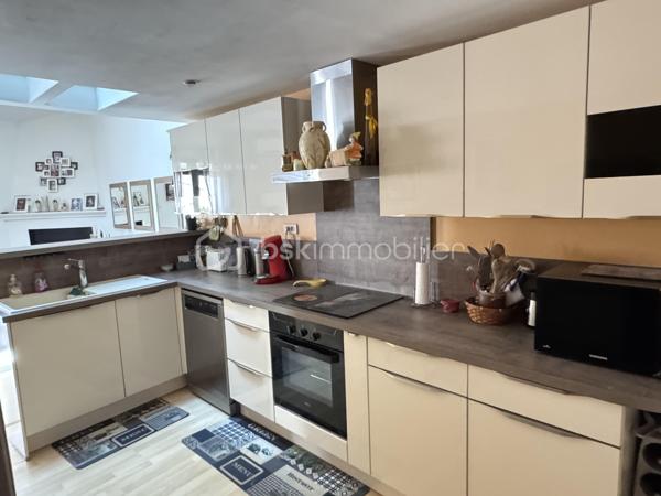 Situé dans une maison de ville en pierre divisée en seulement deux lots, cet appartement bénéficie de l'esprit et de l'indépendance d'une maison de ville. Ses beaux volumes, son cachet authentique et sa grande terrasse en font un bien rare, idéal pour une vie de famille confortable.

Dès l'entrée, vous apprécierez les nombreux espaces de rangement astucieusement aménagés, avec un débarras créé dans une ancienne cuve ainsi qu'un espace de stockage sous l'escalier. Le premier étage accueille une agréable pièce de vie lumineuse comprenant un séjour convivial et une cuisine aménagée et équipée. Cet espace s'ouvre directement sur une terrasse d'environ 16 m², parfaite pour profiter des beaux jours en toute tranquillité.

L'espace nuit principal se compose de deux belles chambres d'environ 16 m² et 15 m², dont une dispose d'un placard intégré. Une salle de bain équipée d'une baignoire et d'une douche, un WC indépendant ainsi qu'une buanderie complètent ce niveau particulièrement fonctionnel.

Au second étage, vous découvrirez une vaste pièce pouvant être aménagée selon vos besoins en chambre supplémentaire, salle de jeux ou espace de loisirs. Une mezzanine vient compléter cet étage et pourra accueillir un bureau, un coin détente ou un couchage d'appoint. Les espaces mansardés apportent beaucoup de charme et de caractère à l'ensemble.

Côté confort, le bien bénéficie de prestations appréciables avec une climatisation réversible dans le séjour, le double vitrage, des volets roulants électriques sur la majorité des ouvertures, la fibre optique installée ainsi qu'un visiophone. Les peintures ont été récemment refaites et le cumulus est récent.

Les travaux importants ont déjà été réalisés puisque la toiture a fait l'objet d'une rénovation récente avec la réfection de la partie principale ainsi que le démoussage et le traitement de la partie restante, offrant ainsi une véritable tranquillité aux futurs propriétaires.

Vous serez séduits par le cachet de la pierre, les beaux volumes, les nombreux rangements, et la grande terrasse. Un bien chaleureux et fonctionnel, parfaitement adapté à une famille, à un couple avec enfants ou à toute personne recherchant une résidence principale alliant charme et confort.

Charges annuelles : 477 €.

Une visite s'impose pour apprécier pleinement le potentiel et l'atmosphère unique de ce bien. Contactez moi dès aujourd'hui pour organiser votre découverte.