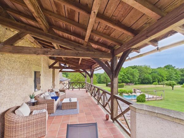 Belle maison de maître en pierre située dans un paysage vallonné en pleine campagne