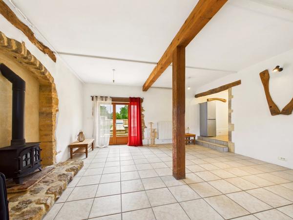 Belle maison de maître en pierre située dans un paysage vallonné en pleine campagne
